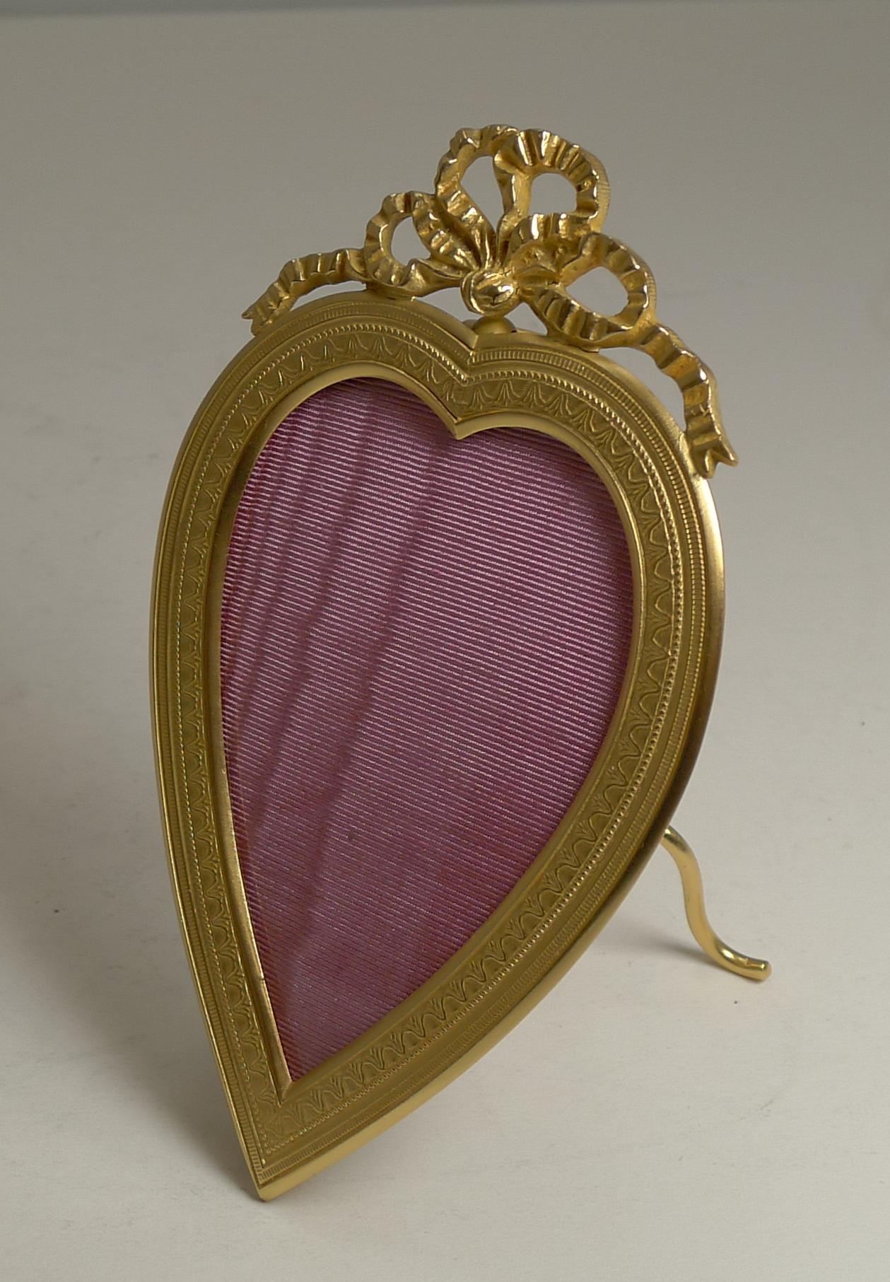 Pretty as a picture and about as romantic as they come. This small French bronze picture frame is covered in gold, beautifully restored to it's former glory.

The frame stands on a folding easel stand topped by a little ring for wall hanging if