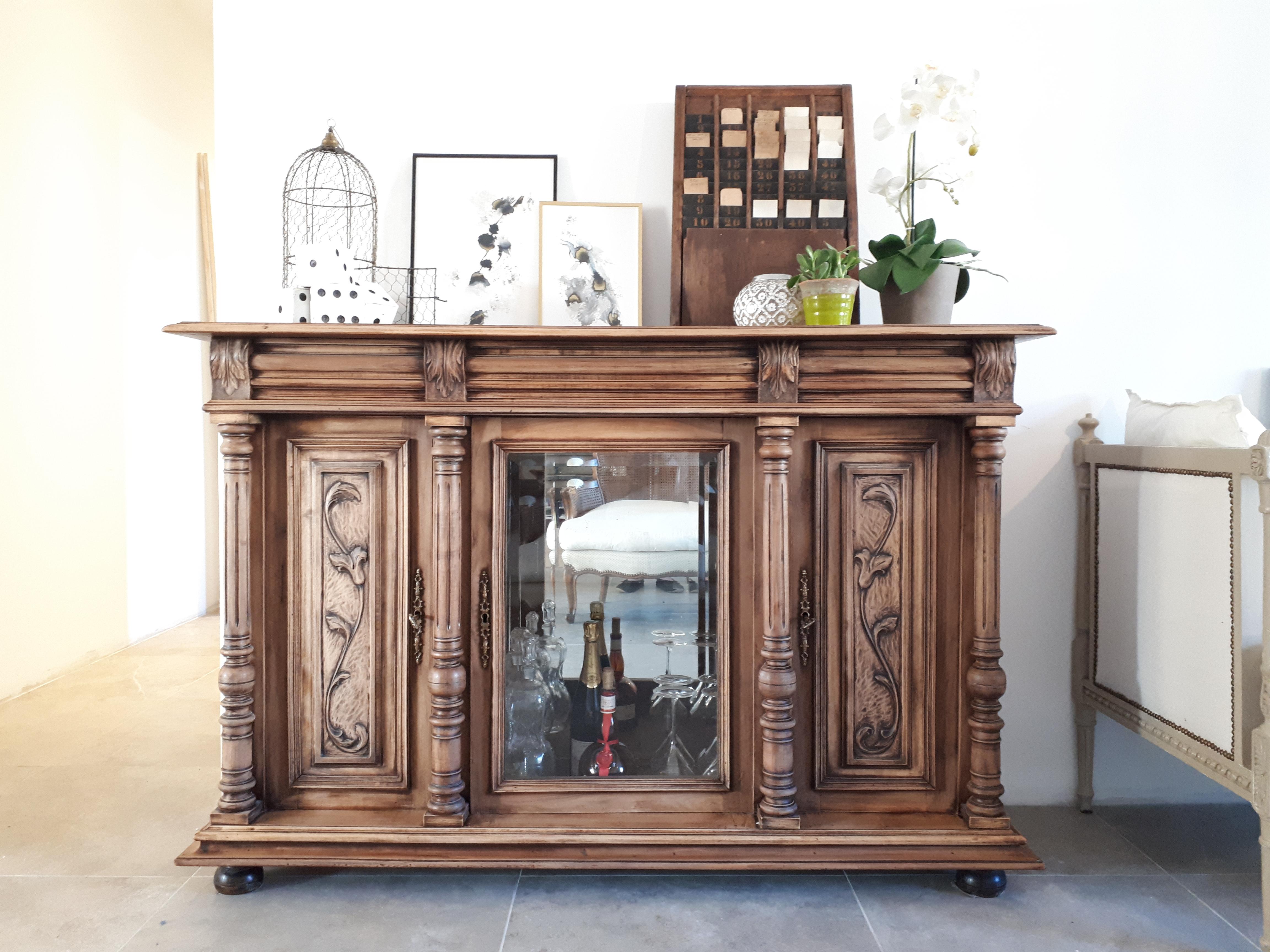 Antique French style Henri II sideboard with generous shapes and four turned wooden columns. 
The decor is hand-worked and represents plant forms such as acanthus leaf on the upper headband. 
The favorite for this piece of furniture is the central