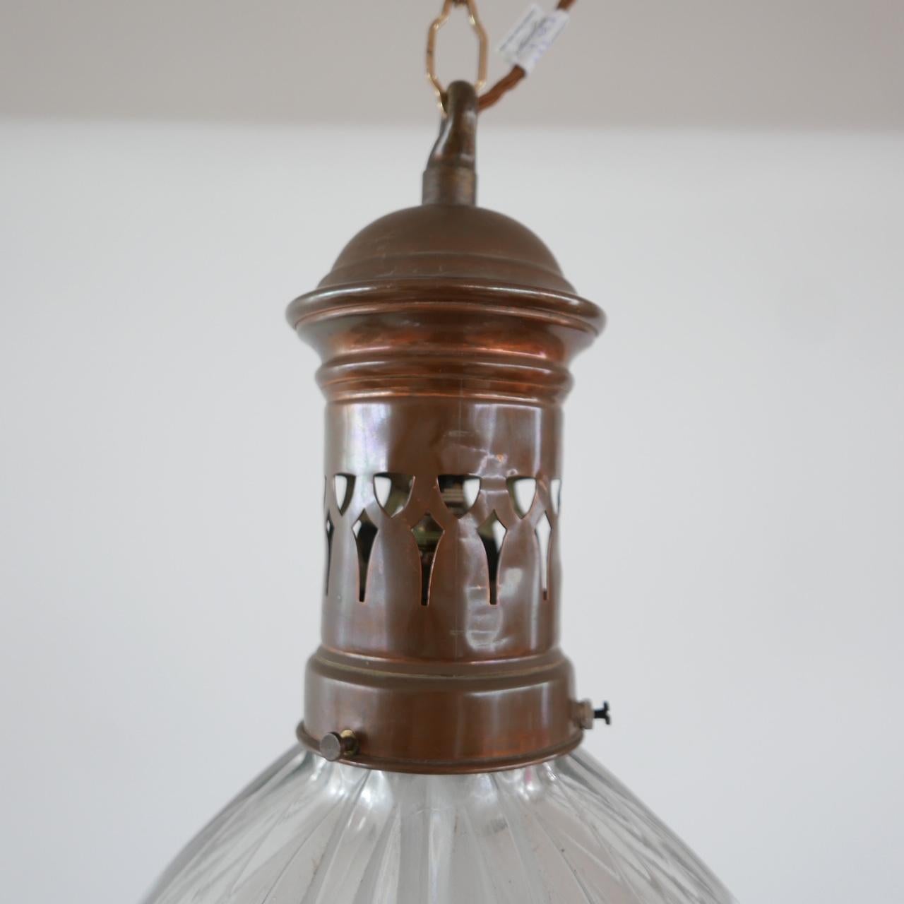 A holophane French pendant light. 

Brass rim and gallery and brass finial to base. 

Ribbed pressed glass top and diffused glass base. 

Lacking one finial to the rim. 

Re-wired and PAT tested. 

No chain or rose were retained.