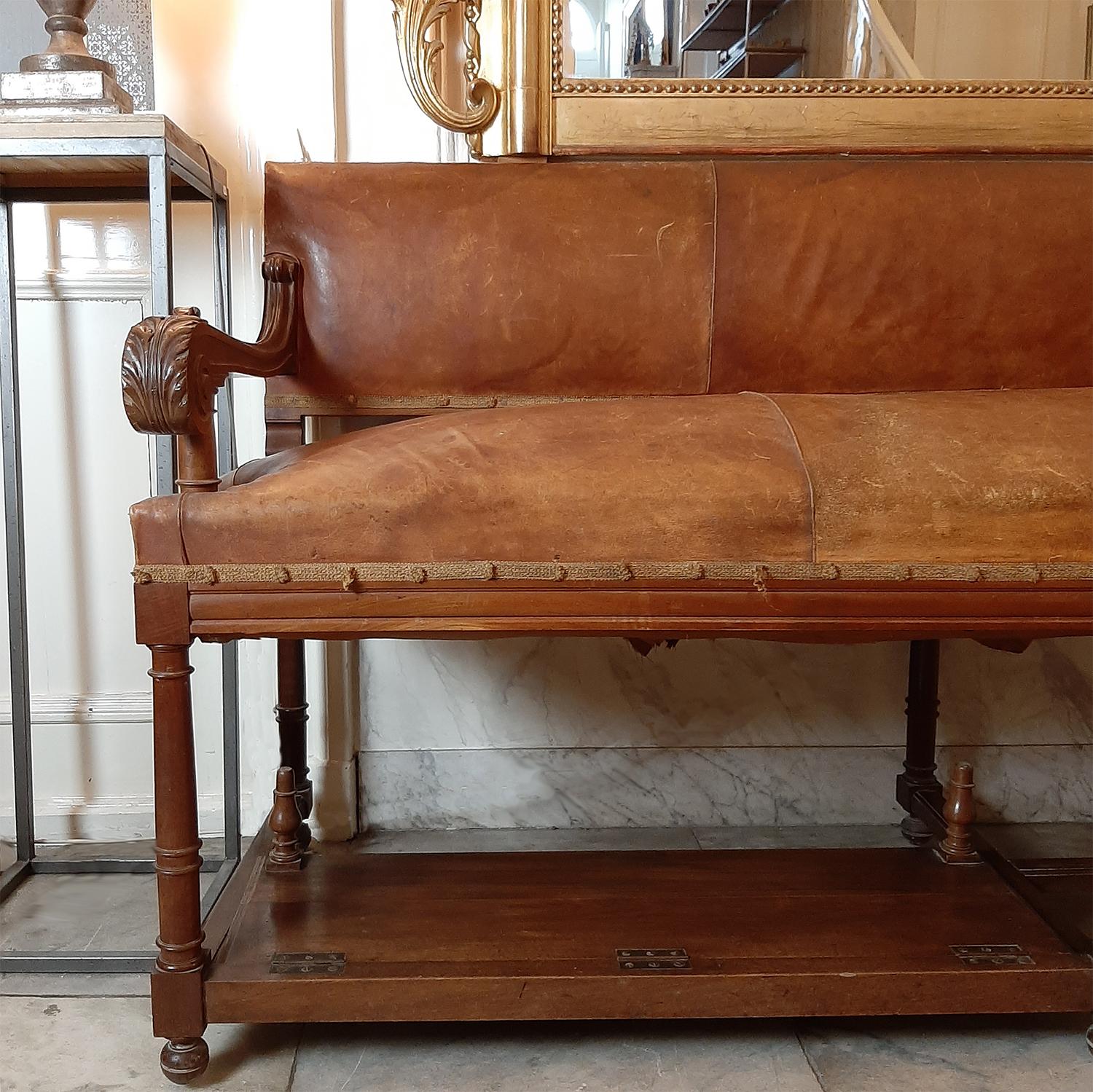Authentic French bench in the primitive style that was found in a hotel entrances or lobby's, circa 1900s. Such an hotel entrance sofa was also often used as a gentlemen’s shoe shine bench and the footrests can be folded up and down.
This stunning