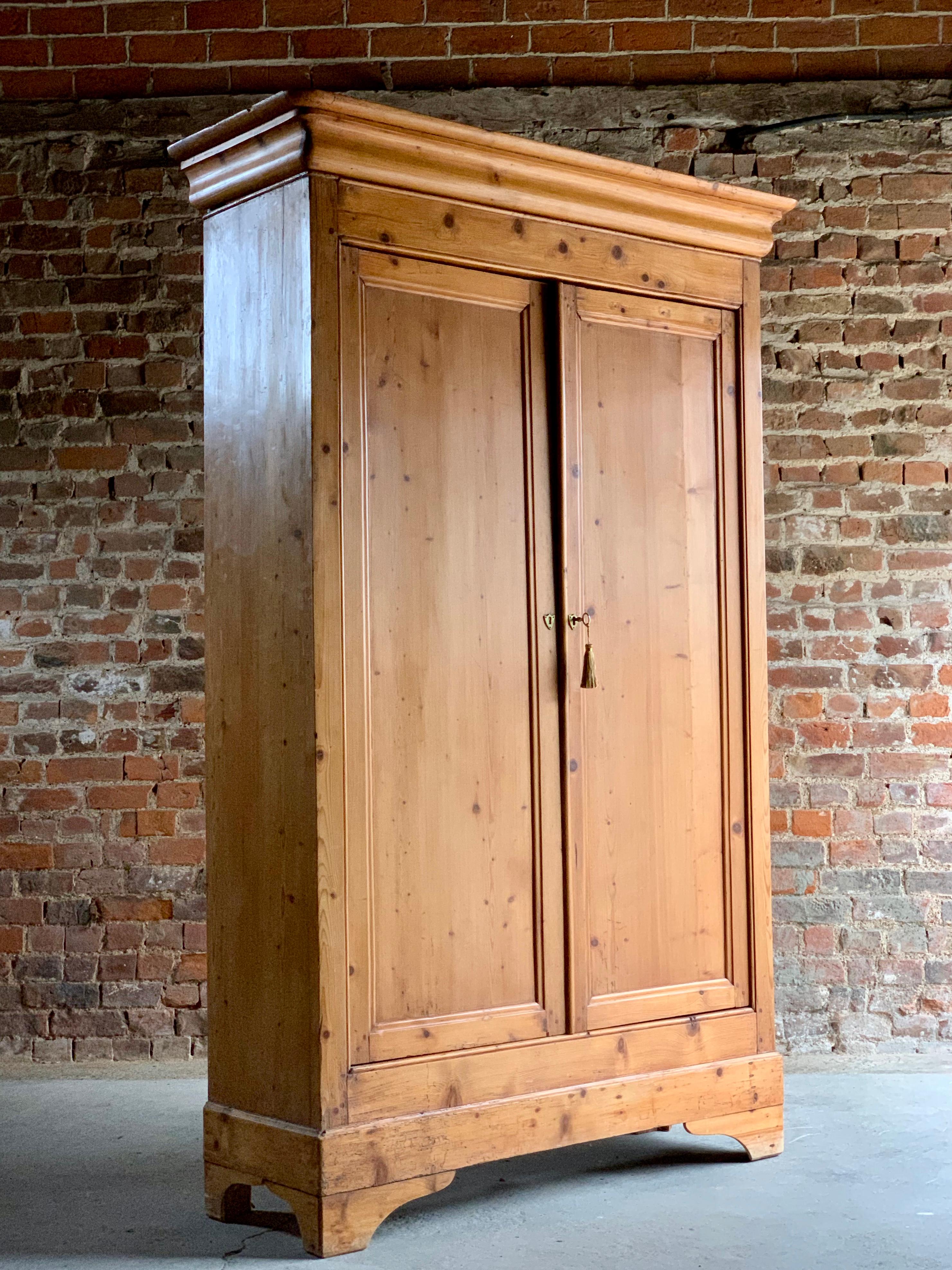 A stunning antique French stripped pine two-door Housekeepers cupboard circa 1890, The corniced top over two panelled doors enclosing four removable shelves, one original working key with brass escutcheons to the doors, raised on bracket