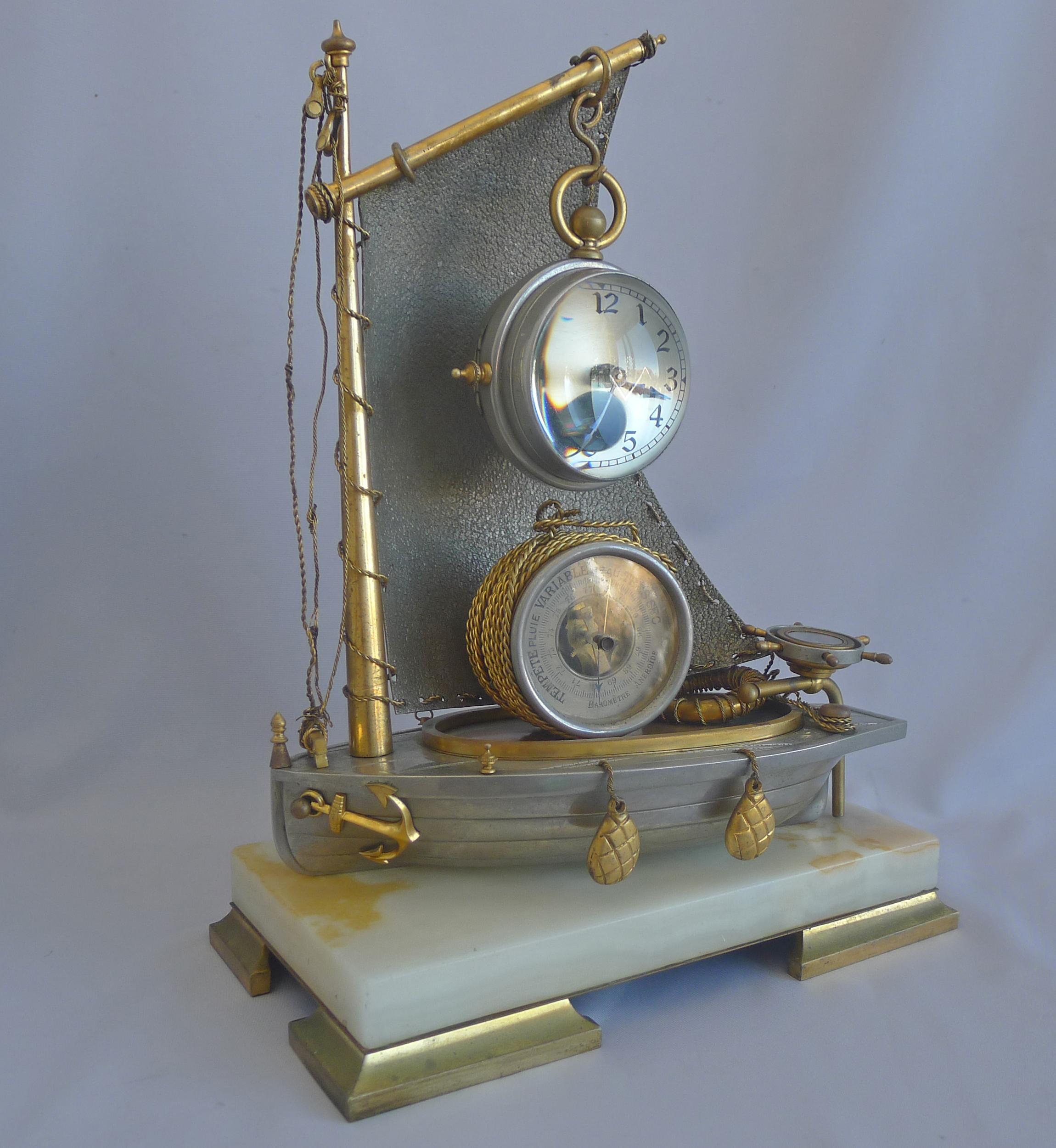 A very rare antique French Industrial series 'Sailboat' compendium clock. Set on four gilt bronze feet and a white onyx base. The silvered bronze hull of the boat with two gilt bronze bouys hanging on the side, as well as the anchor, also in gilt