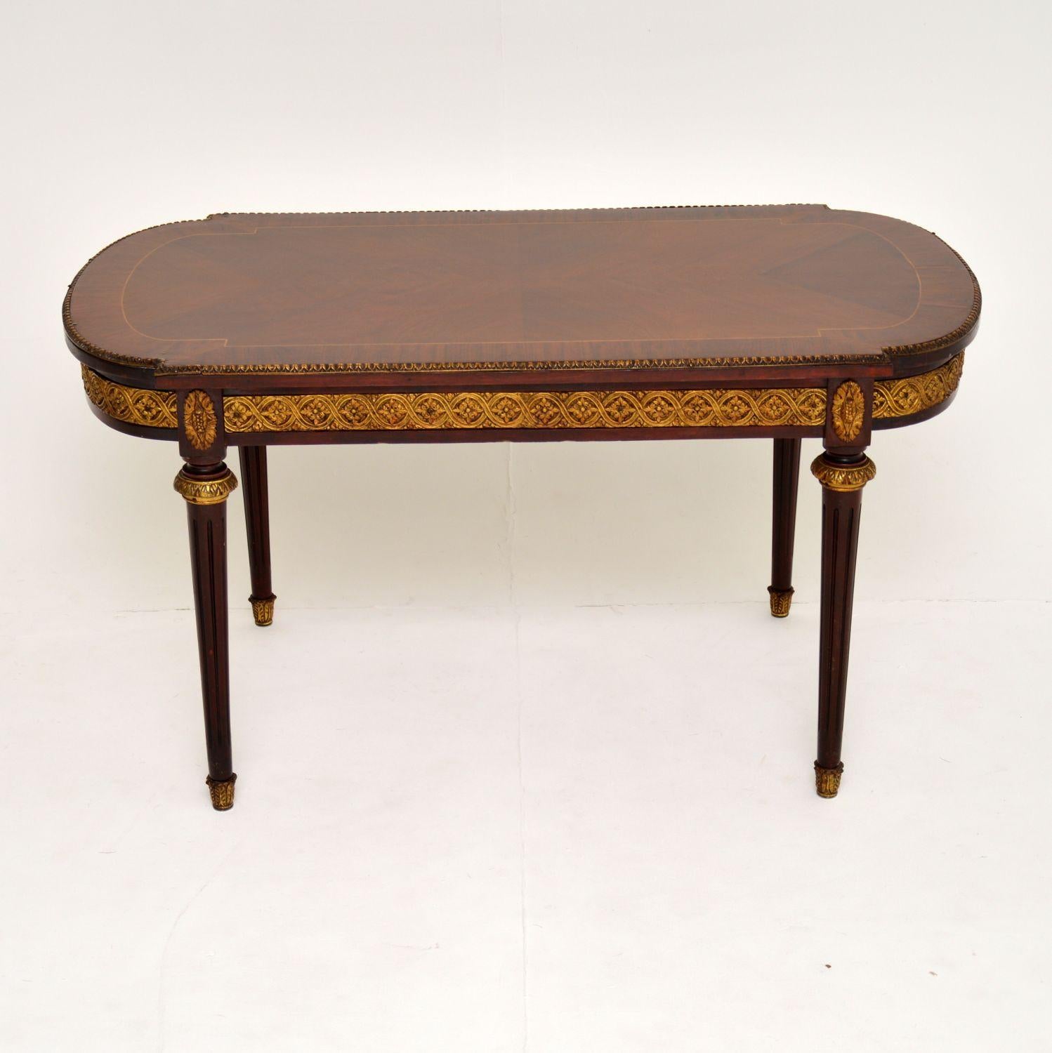 Antique French style mahogany and kingwood coffee table in very good original condition and dating from circa 1930s period.

It has a kingwood top bordered with satinwood inlay and mahogany crossbanding. There is a gilt bronze top edge and frieze