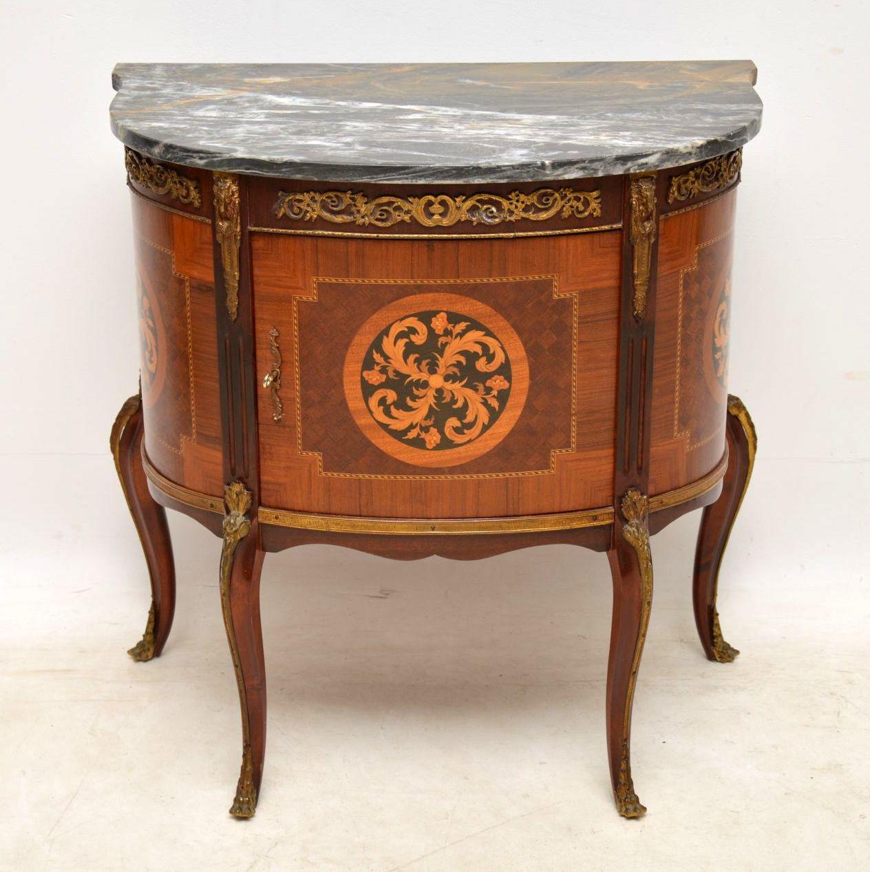 Small antique French marble top cabinet with many different woods involved. It's predominately mahogany and kingwood, however there are many other more exotic woods set into it in the form of inlays, parquetry and marquetry. This cabinet is all in