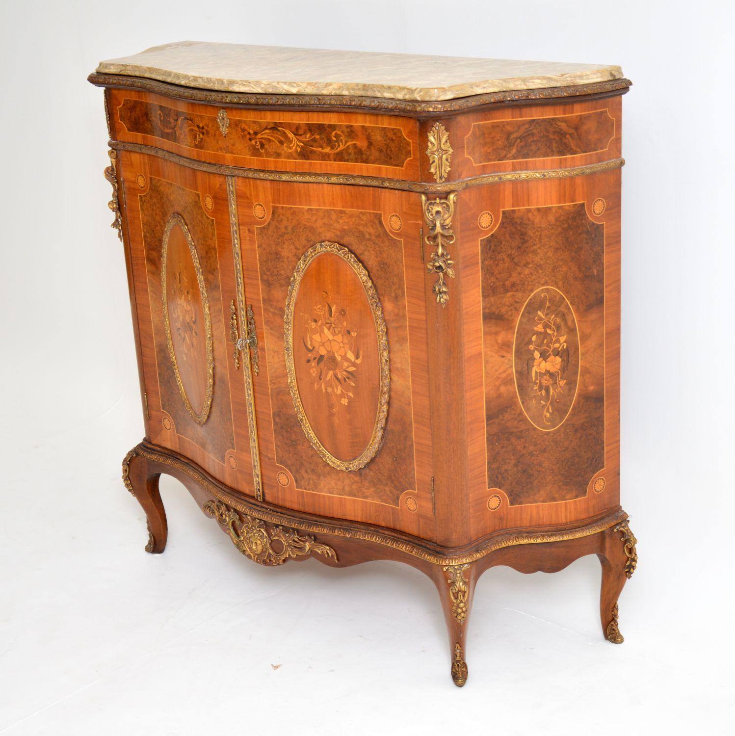 Antique French style marble top cabinet with stunning floral marquetry panels made up of many exotic woods and inset into burr walnut surroundings. The middle oval panels are convexed and surrounded by gilt bronze mounts. The gilt bronze mounts are