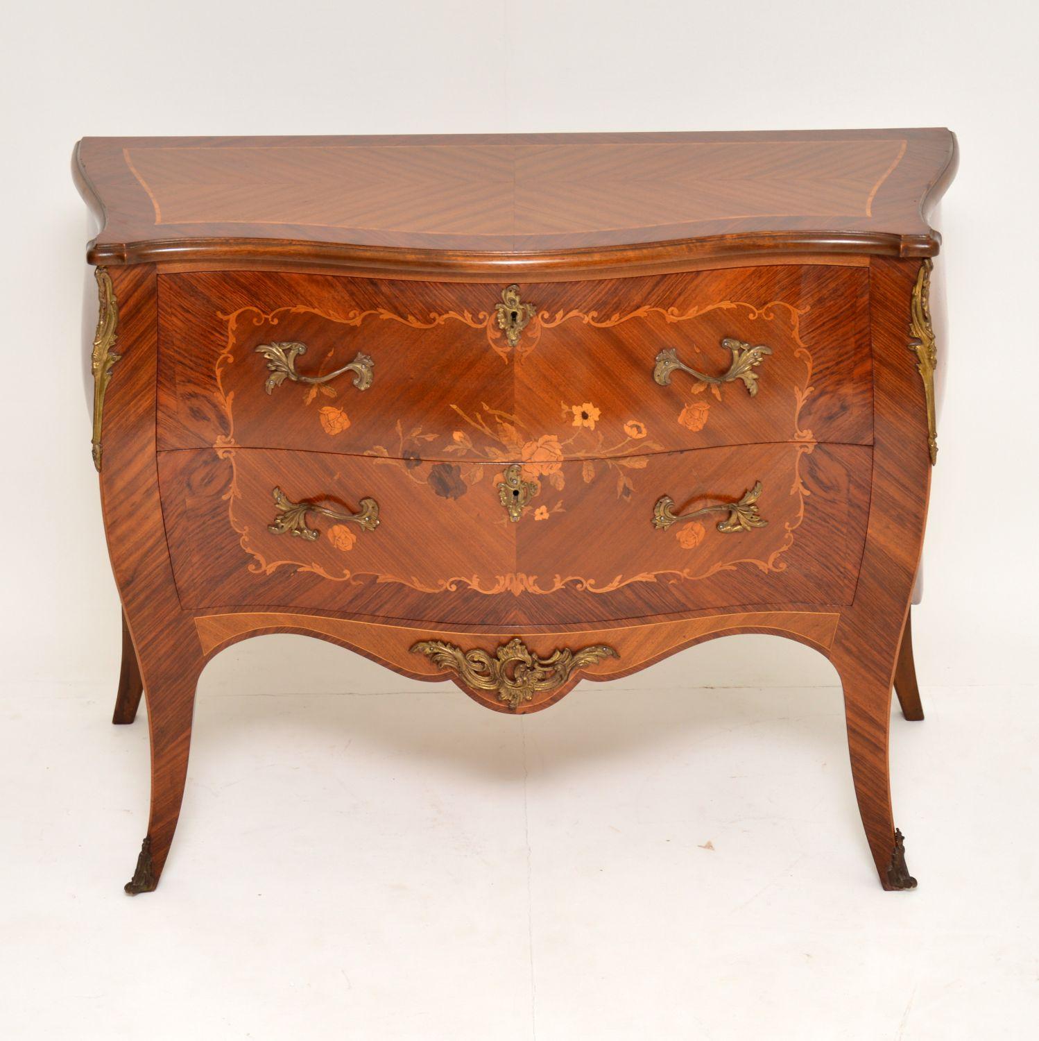 Antique French style bombe chest with inlays and floral marquetry on the drawer fronts and sides. It’s in very good condition and I would date it to circa 1930s period. Unlike most of these commodes, this one has a polished top instead of marble. It