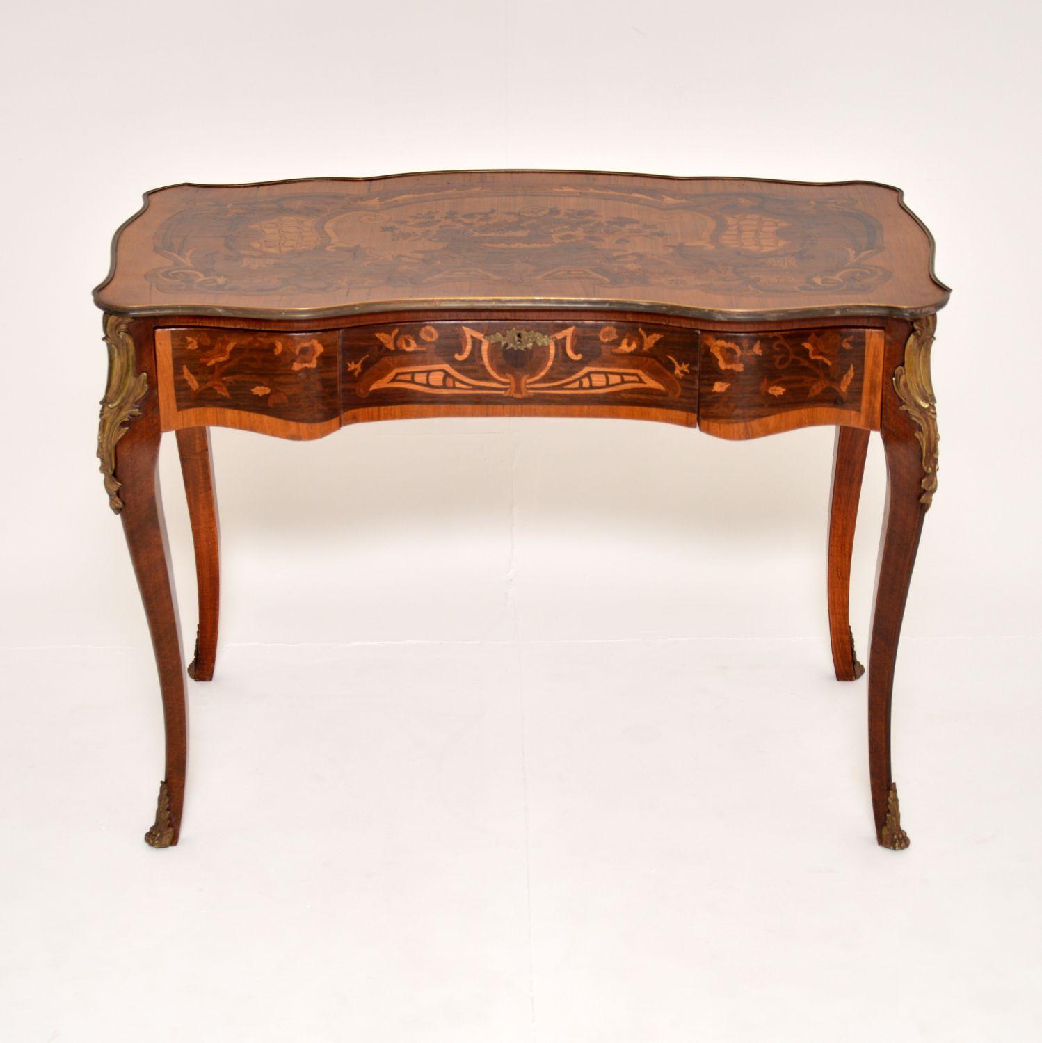 A stunning antique French Louis XV style bureau plat desk, which I would date from around the 1930’s period.
It is of superb quality and is beautifully inlaid with stunning marquetry of various woods. This has an inverted breakfront design with