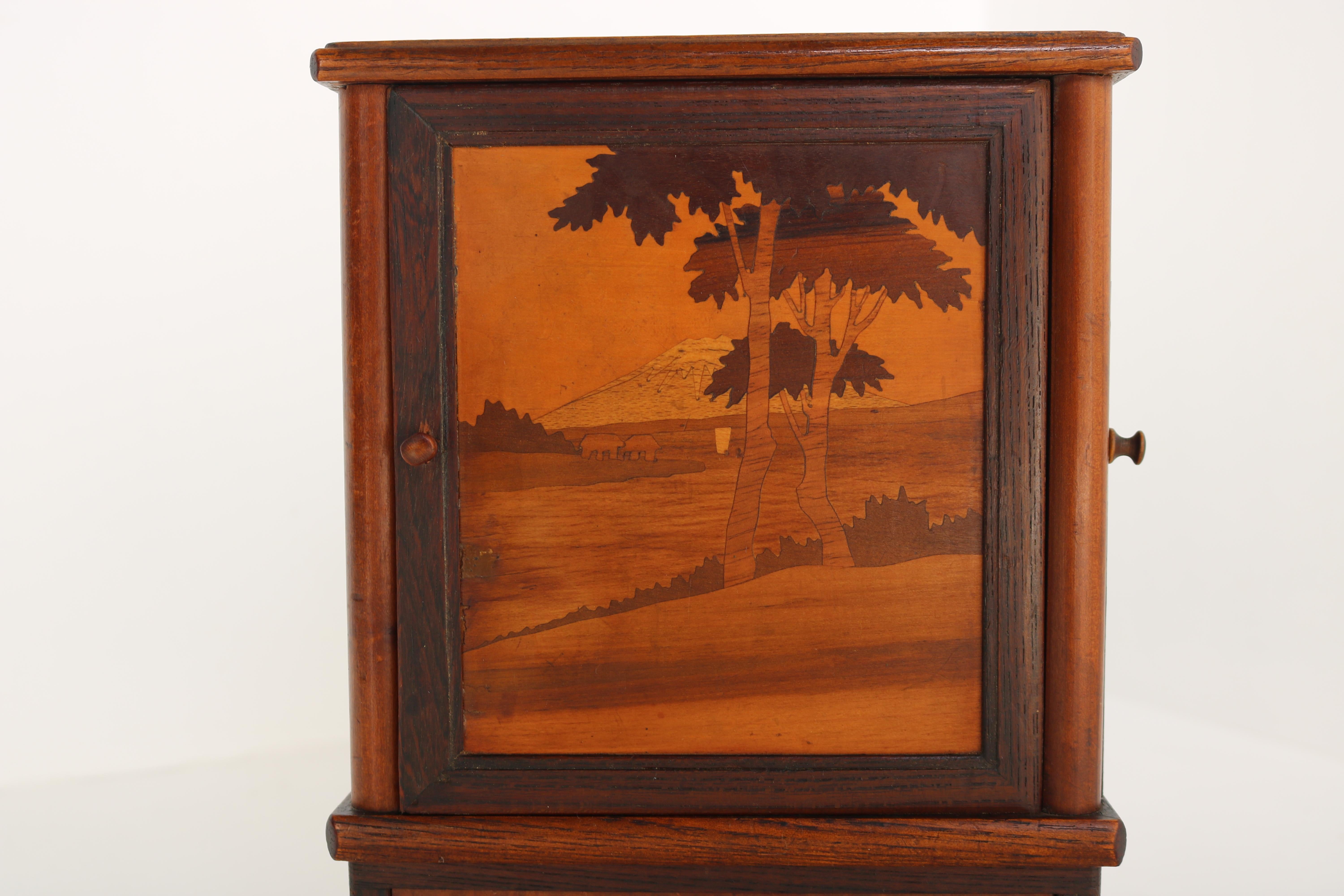 Lovely antique French cigar box / cigarette cabinet from 1900. with various inlaid woods. Gorgeous craftsmanship 
The cabinet is decorated with landscapes , mountains , trees , boats , animals & rivers. all done by hand with great details & colors.