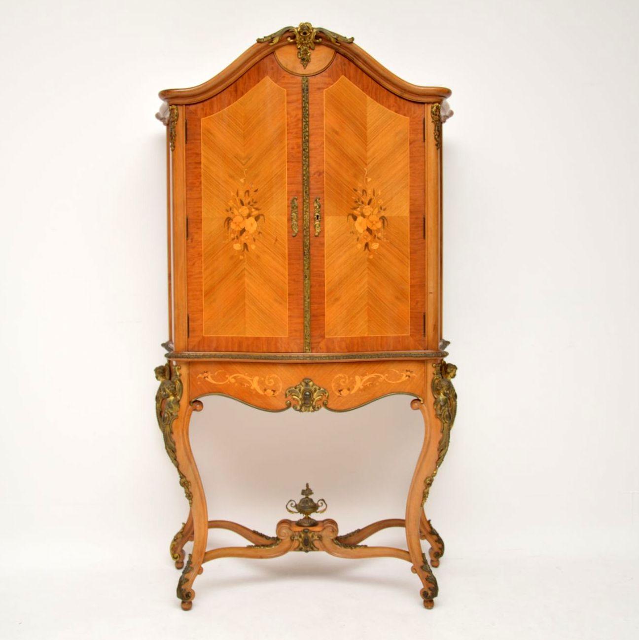 This French antique Kingwood drinks cabinet has a wonderful shape & some exceptional fine details. It has a serpentine shaped front, two doors with floral marquetry panels & two more on the sides, more marquetry on the bottom drawer & on the bottom