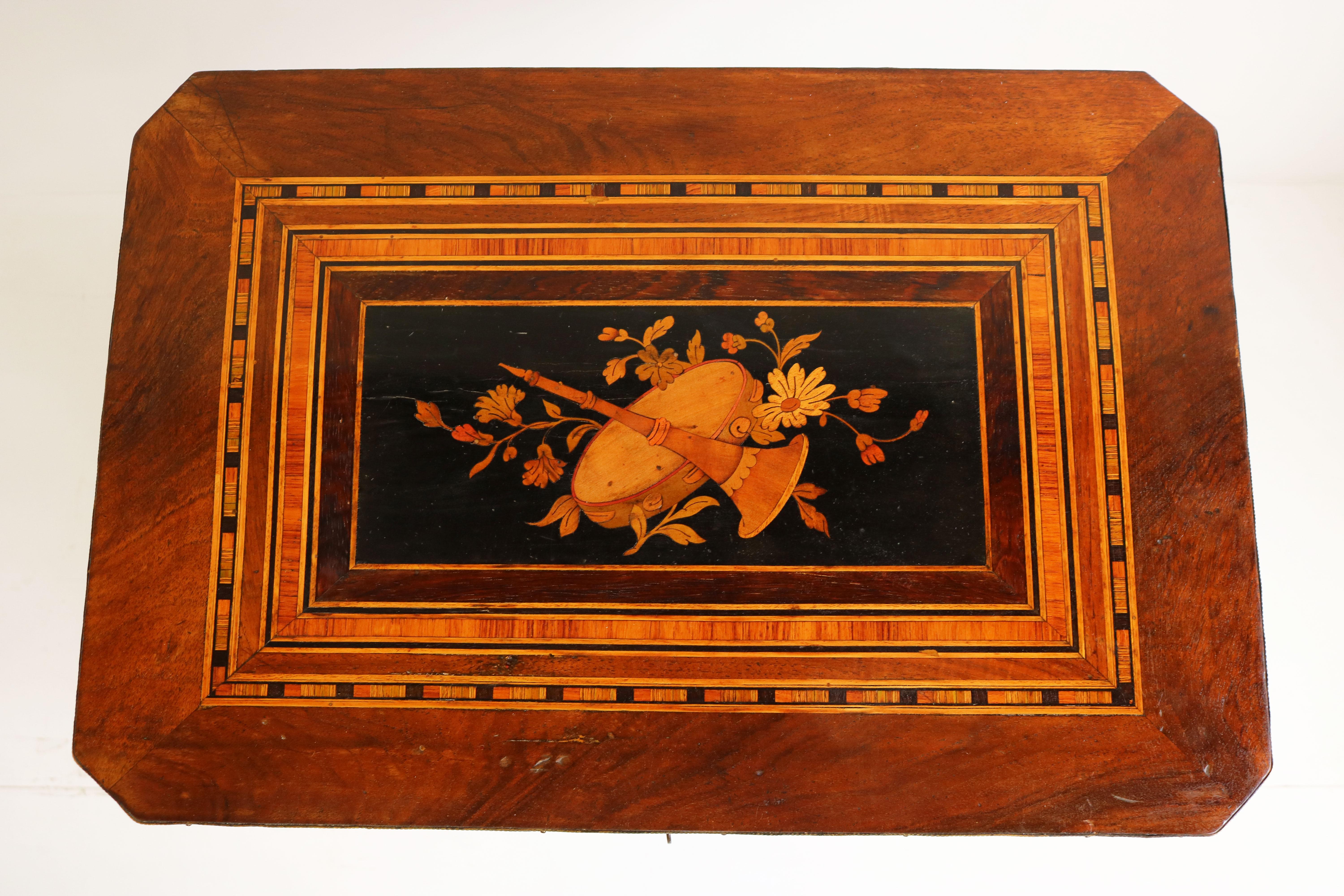 A very nice Napoleon III side table inlaid with marquetry 1860-1870. Standing on curved and blackened legs with connecting platform. 
The beautiful instrumental inlaid top and floral inlaid shelf at the bottom are masterfully crafted from various