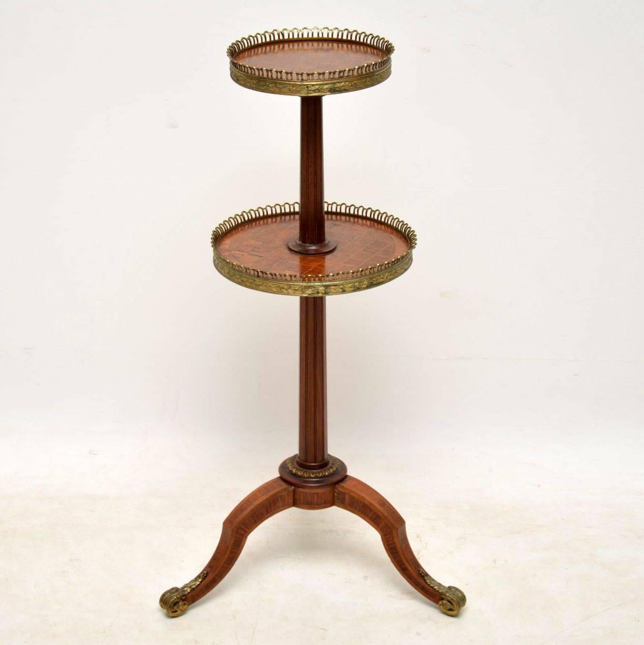 Antique French two-tiered étagère with kingwood parquetry, inlays and gilt bronze mounts of exceptional quality. It has a fluted central column and sits on tripod legs. There are kingwood panels on the tops and sides of the tripod legs. This table