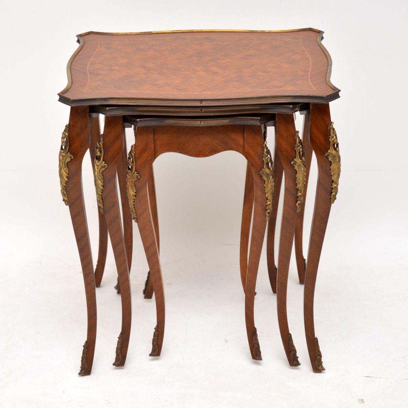 Antique French Kingwood nest of tables with gilt bronze top edges, plus gilt bronze mounts and feet. They have parquetry tops, inlaid and cross banded. These tables are in good original condition and have just been French polished. The gilded mounts