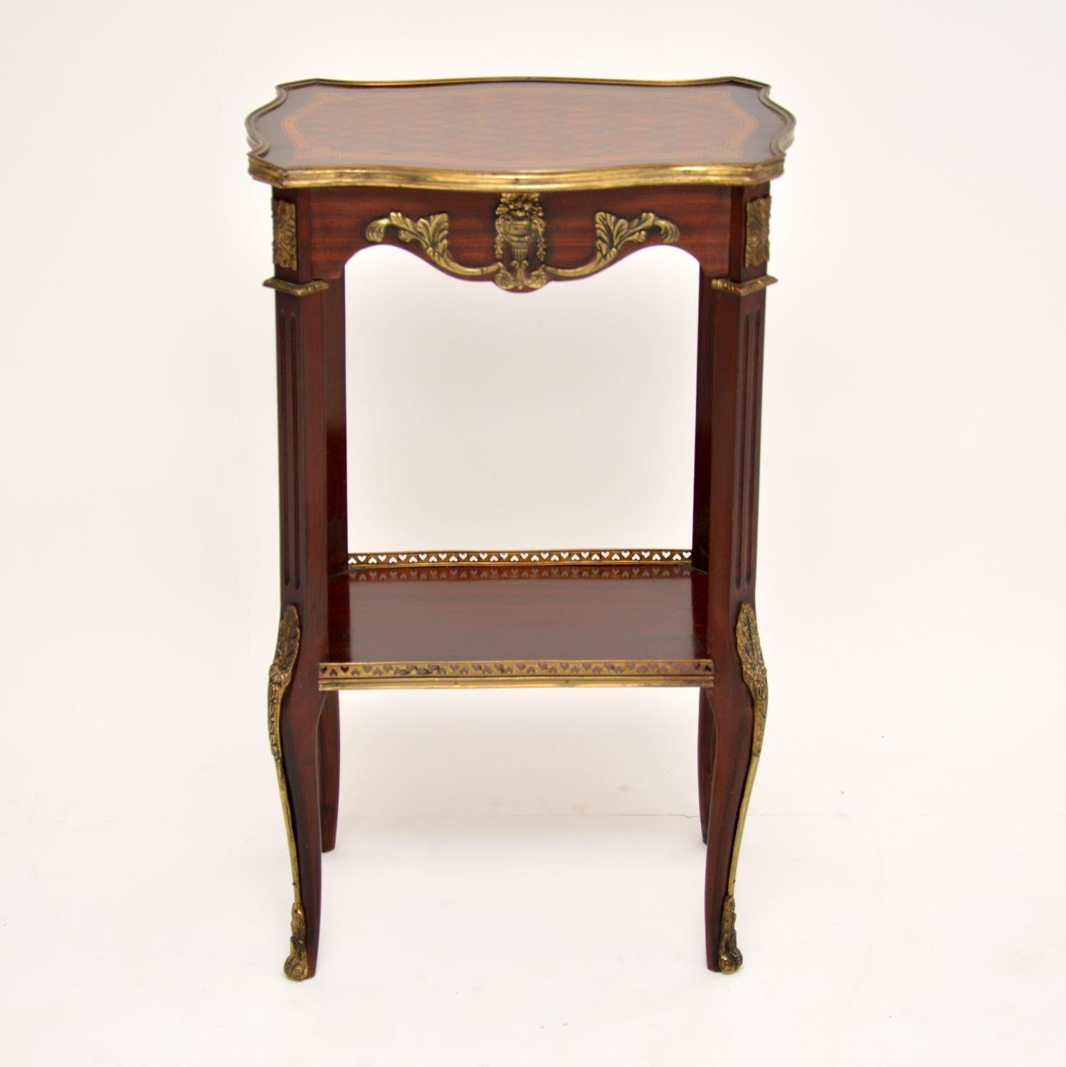 Antique French style mahogany side table with lots of detailed decoration in the form of inlays, parquetry and gilt metal. The top has parquetry and inlays made up from various exotic woods and a gilt metal edge. There are many gilt metal mounts all