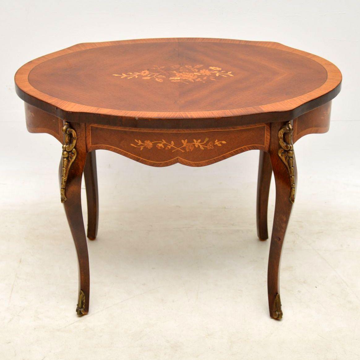 Antique French inlaid walnut coffee table with some exquisite floral marquetry in the middle & around the sides. This table has many fine details with many exotic woods especially within the marquetry. It's also cross banded on the top edges &