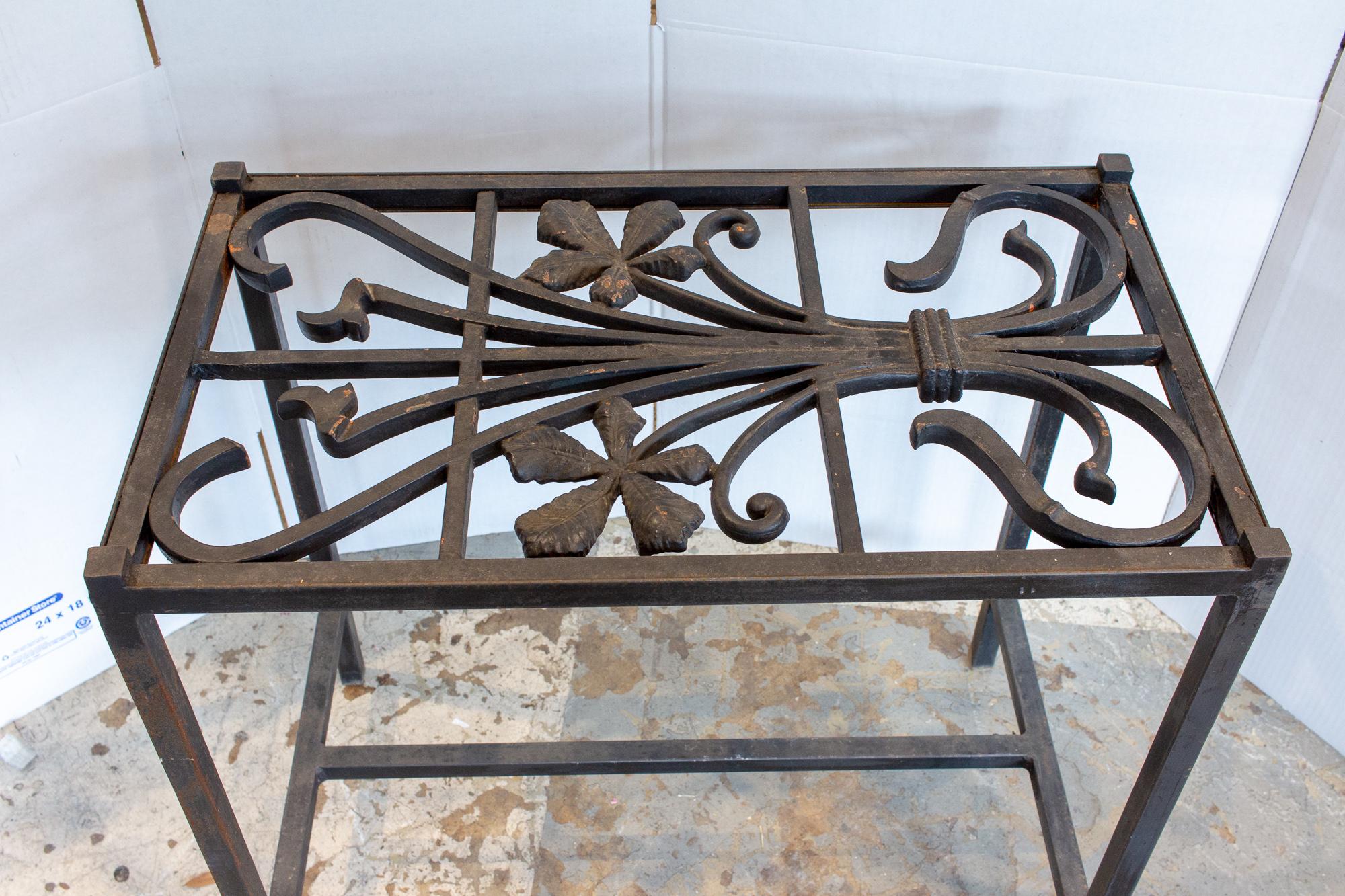 This iron console table has been crafted with a wonderful, iron art nouveau top, with a simple wrought iron table frame. The piece could be used indoors or out, as a small accent table. The floral details of the top make a feminine statement piece