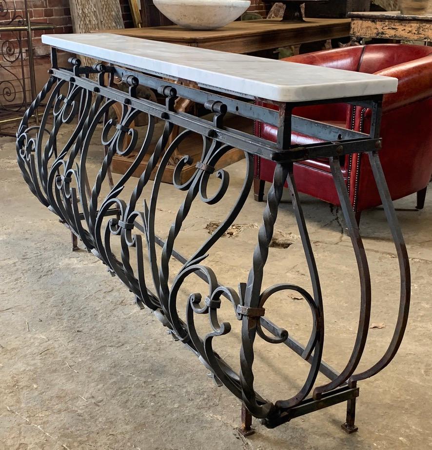 A beautiful French wrought iron and marble balcony console table. Made from an old French balcony. The iron base still has its original old paint in places. The top is made from solid Carrara marble. Early 20th century.