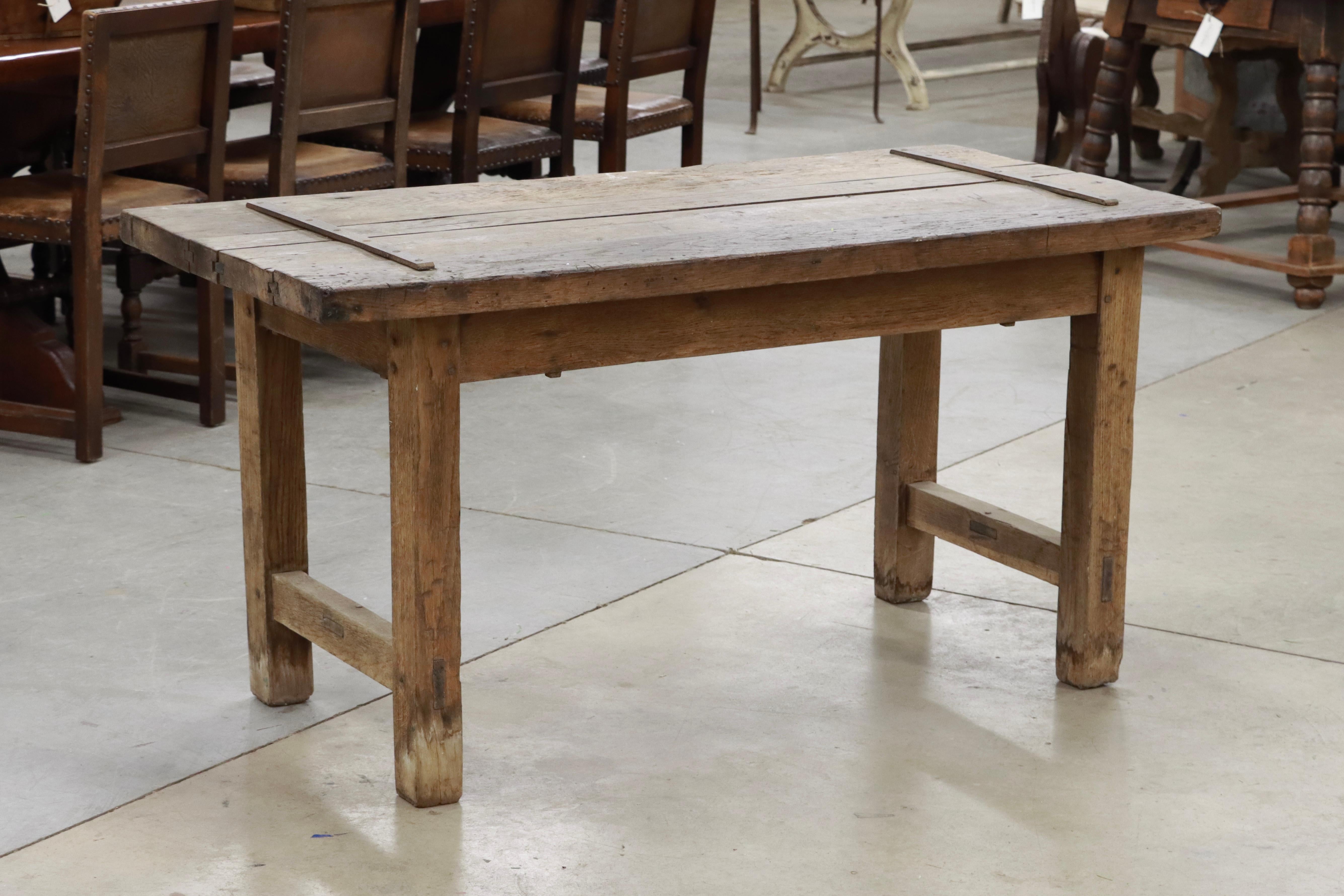 Very substantial and unique antique oak wood table. The top is a thick and chunky ancient French jailhouse door (ca. 1600's) married with a 19th c French oak base.

Would make an excellent dining table or desk! 