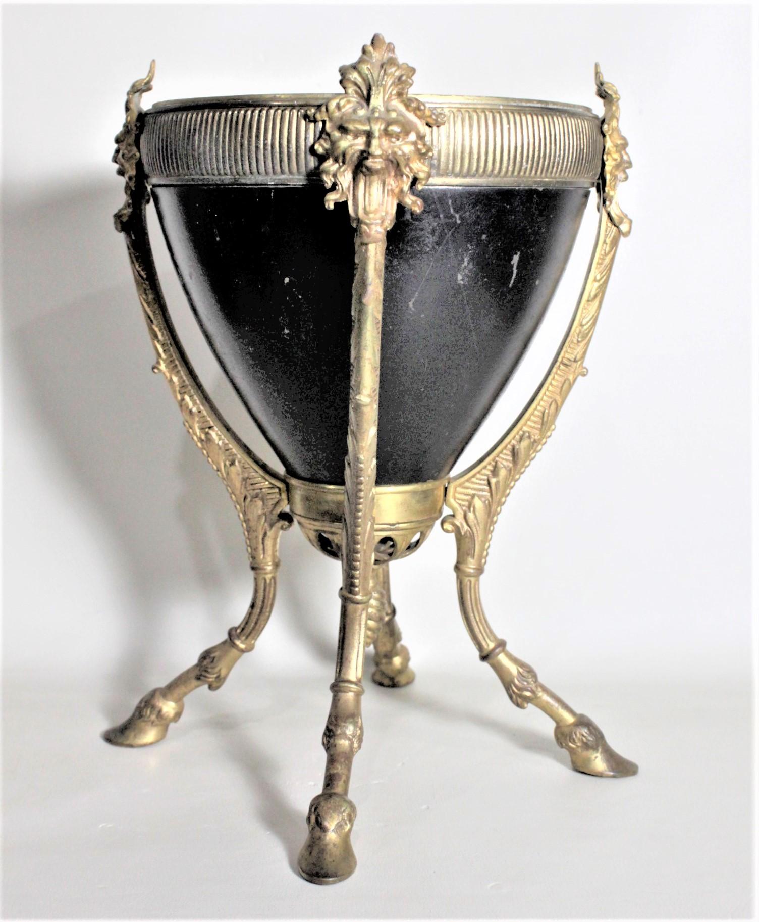 This antique gilt bronze and cast iron jardinière is unsigned, but presumed to have been made in France in approximately 1900 This planter is done with a conical shaped cast iron pot which has been cold-painted a glossy black, and a very ornate cast