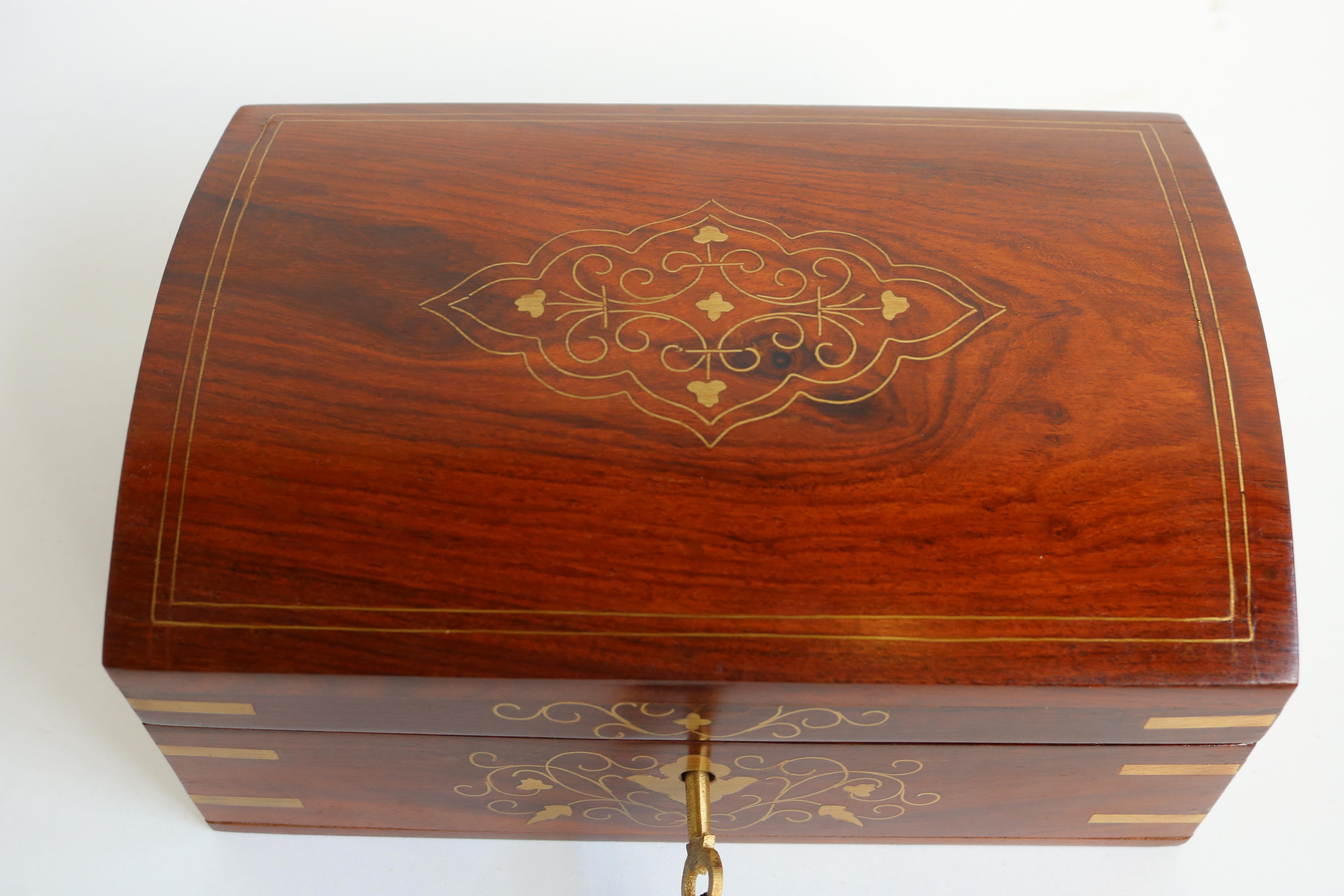 Superb jewelry box from France early 1900s made from solid wood with amazing inlaid brass decorations. 
The jewelry box is richly decorated with brass inlay 
Comes with original lock & key. 
Interior has a removable shelf and is decorated with