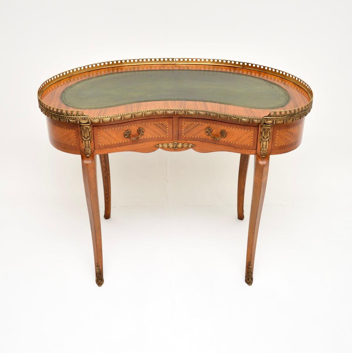 A stunning antique French kidney shaped leather top desk, dating from around the 1930’s period.

It is of fabulous quality, with a solid birch construction and contrasting veneers of various other woods. There are fine gilt bronze mounts throughout