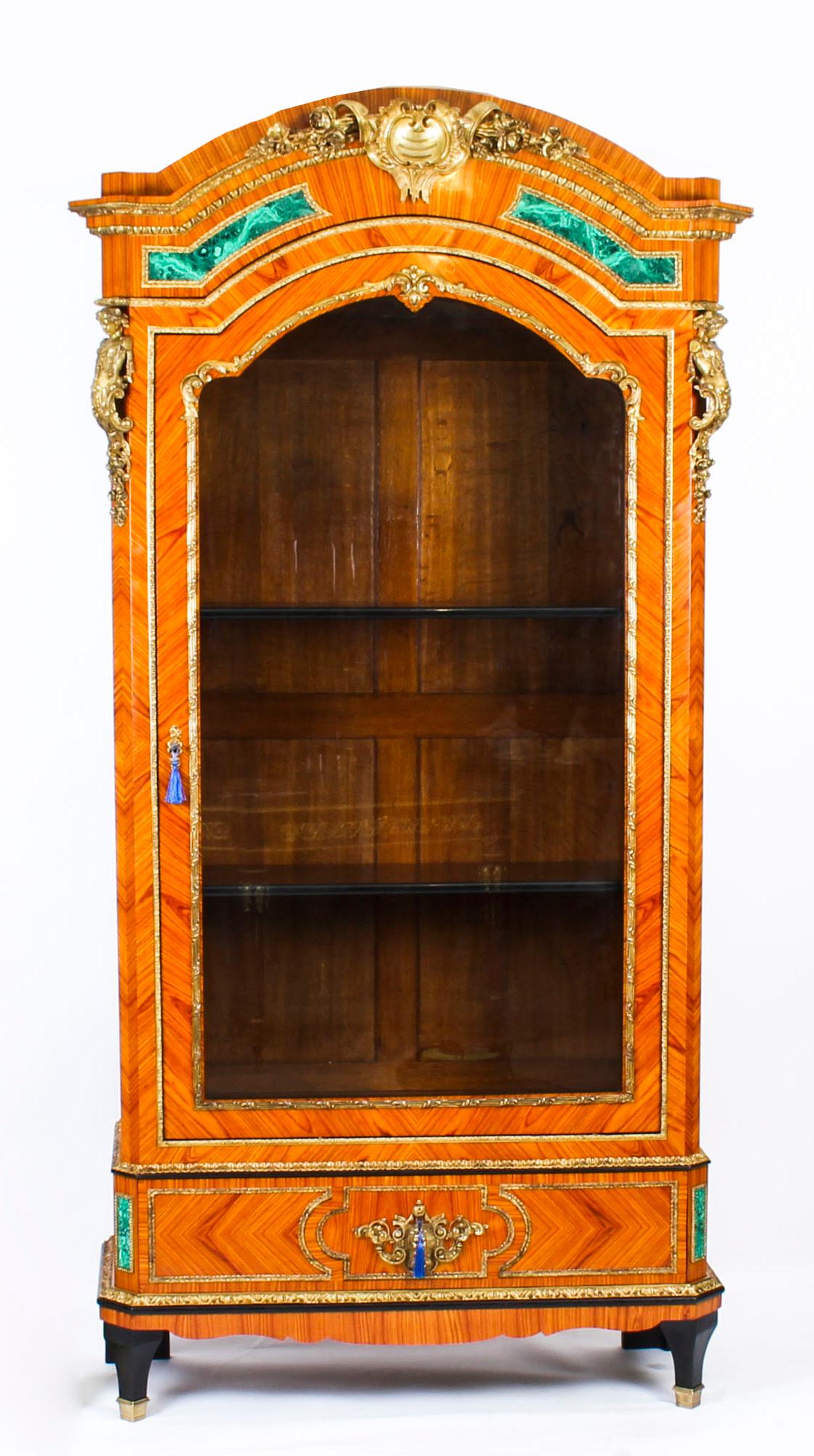 This is a beautiful antique French Malachite and Ormolu mounted vitrine in the French Louis XV manner, circa 1870 in date.

This beautiful cabinet has an abundance of exquisite decorative ormolu mounts inset with malachite. The domed cornice above a