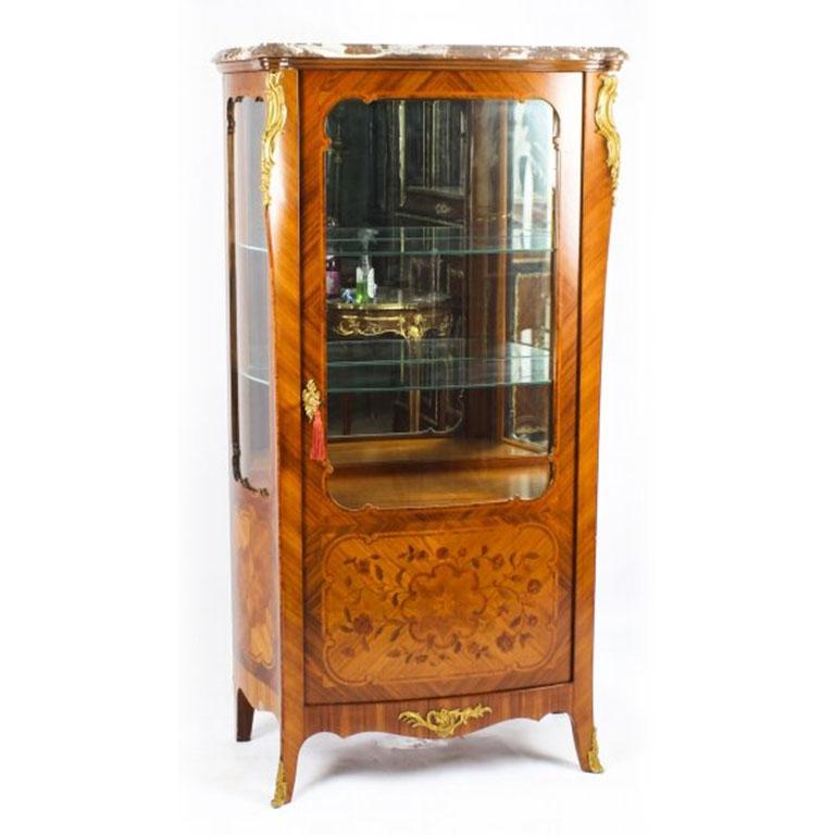 This is a beautiful antique French Louis Revival walnut, marquetry and ormolu mounted vitrine, circa 1880 in date.

This beautiful cabinet has exquisite floral marquetry decoration with gilded bronze ormolu mounts. The shaped marble top and cornice
