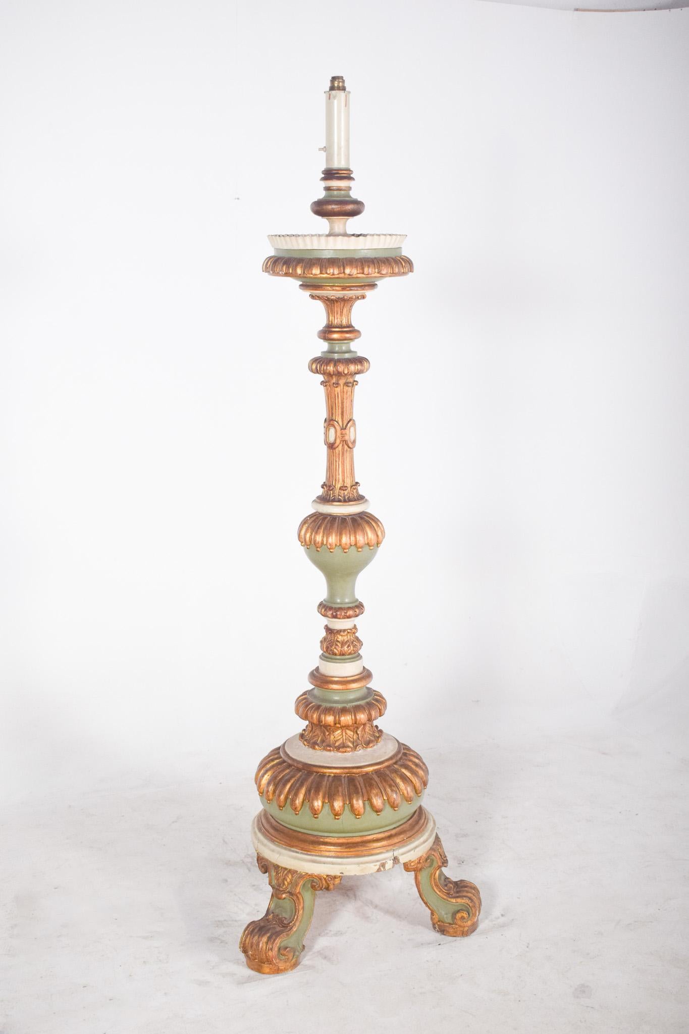 Large carved torch with gilding. In richly carved and polychromed wood, with gilded details and shades of soft green and aged white. The piece has a robust vertical structure, made up of turned elements and reliefs carved in plant and oval shapes,
