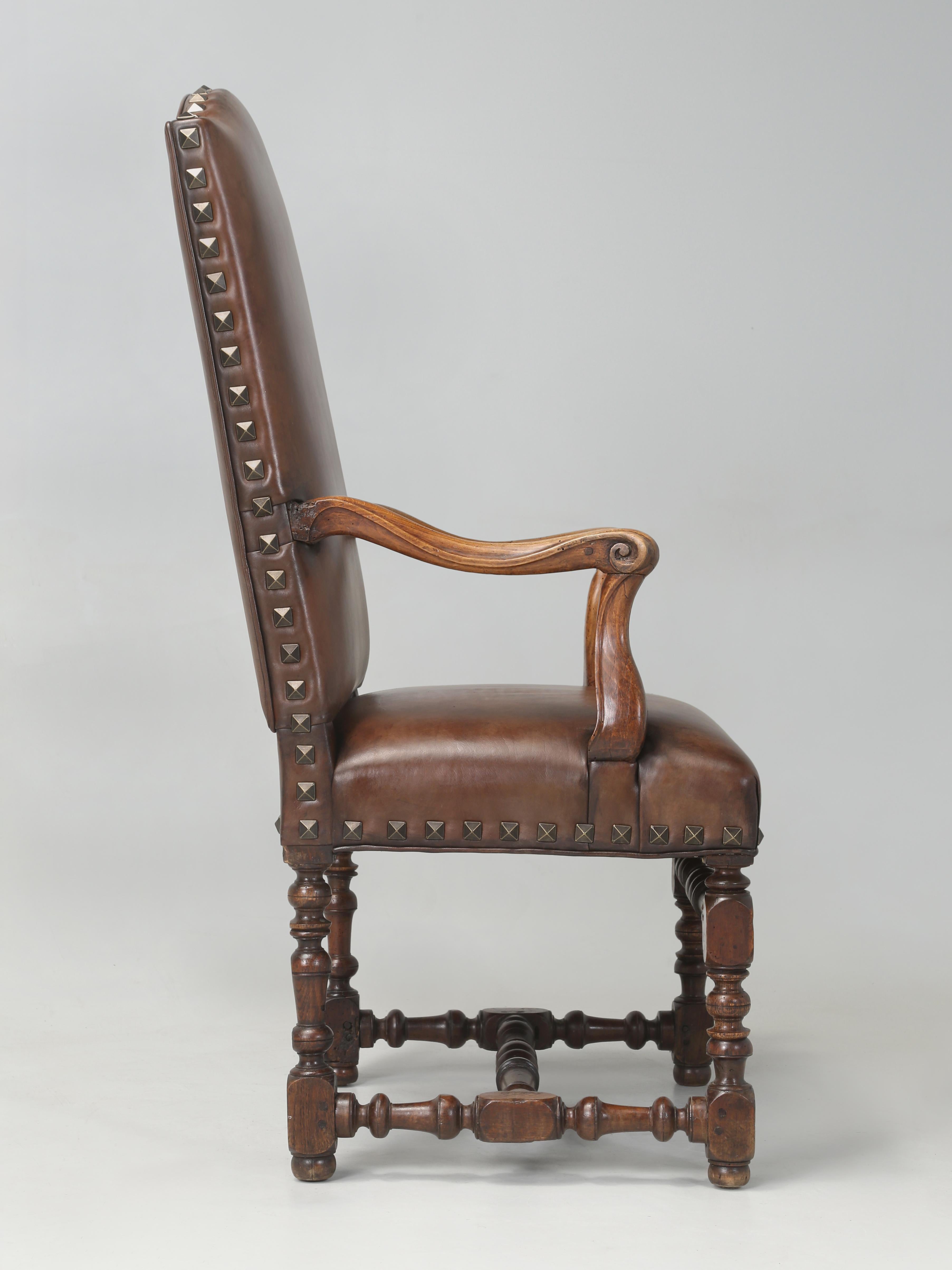 Antique French walnut throne chair or armchair that was completely disassembled, cleaned, glued, and reupholstered with new springs, padding, and high quality dark brown leather. Perfect utilized as either a cozy chair in the family room, next to