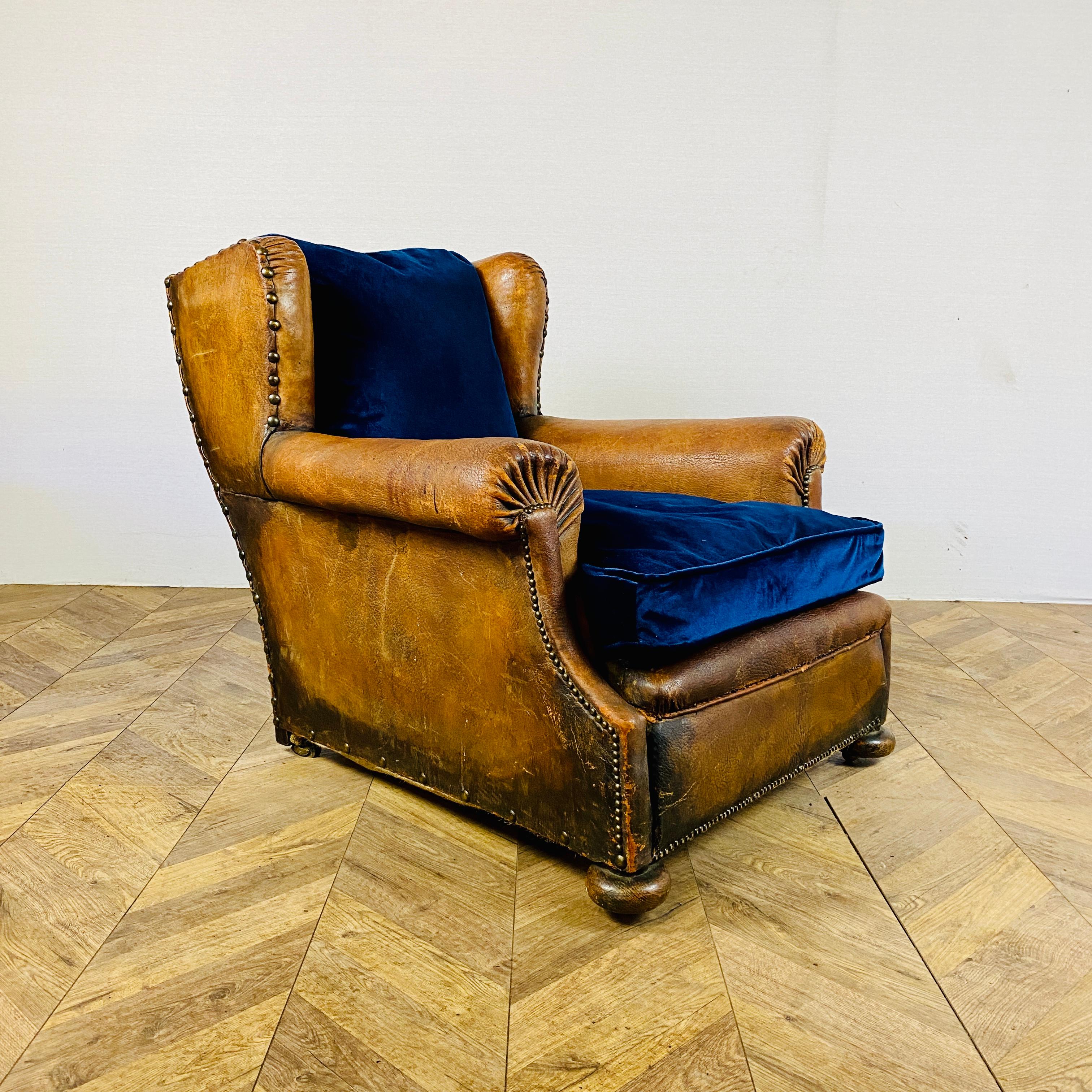 A Lovely Large Antique French leather club armchair on Original Wooden Castors - circa 1900s

The armchair has a wonderfully deep shape with a lovely warm patina. The upholstery was professionally updated to a navy velvet fabric, which is super