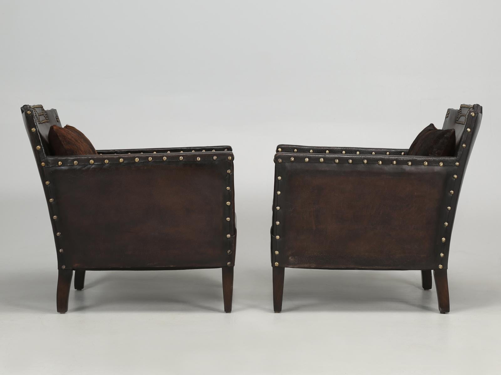 French leather club chairs in a fairly unique style and perfect for tight spaces, while still very extremely comfortable for us larger individuals. Both of these French leather club chairs have gone through our extensive club chair restoration