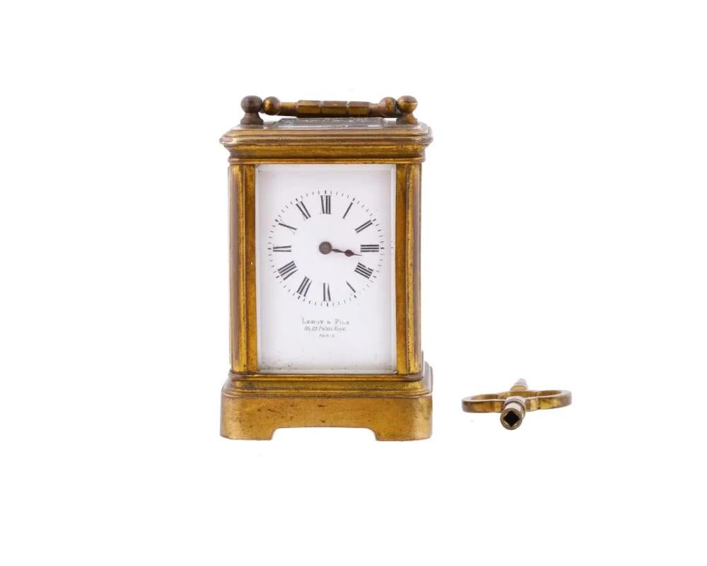 Eine antike französische Miniatur-Kutschenuhr aus dem 19. Jahrhundert mit Schlüsselaufzug. Rechteckiges Gehäuse mit Fuß und Henkel auf der Oberseite aus vergoldeter Bronze. Die Seiten aus Klarglas zeigen das Uhrwerk. Weißes Emailzifferblatt mit