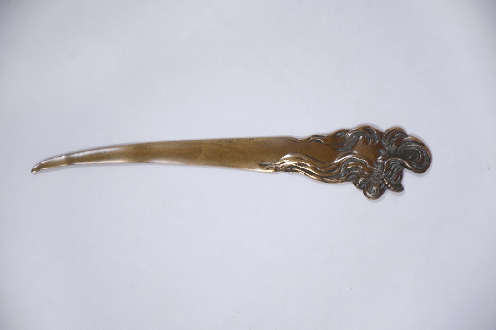 An antique French Art Nouveau letter opener handcrafted out of brass. This intricate piece features a crafted woman a beautiful original patina finish.