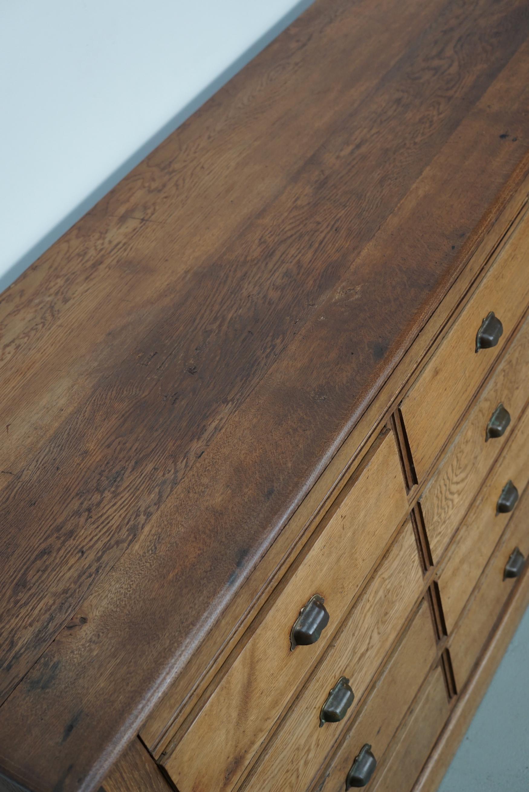 This apothecary cabinet was made around the 1930s in France from oak. It features 16 decent sized drawers with brass handles. The interior dimensions of the drawers are: DWH 48 x 40 x 11 cm.