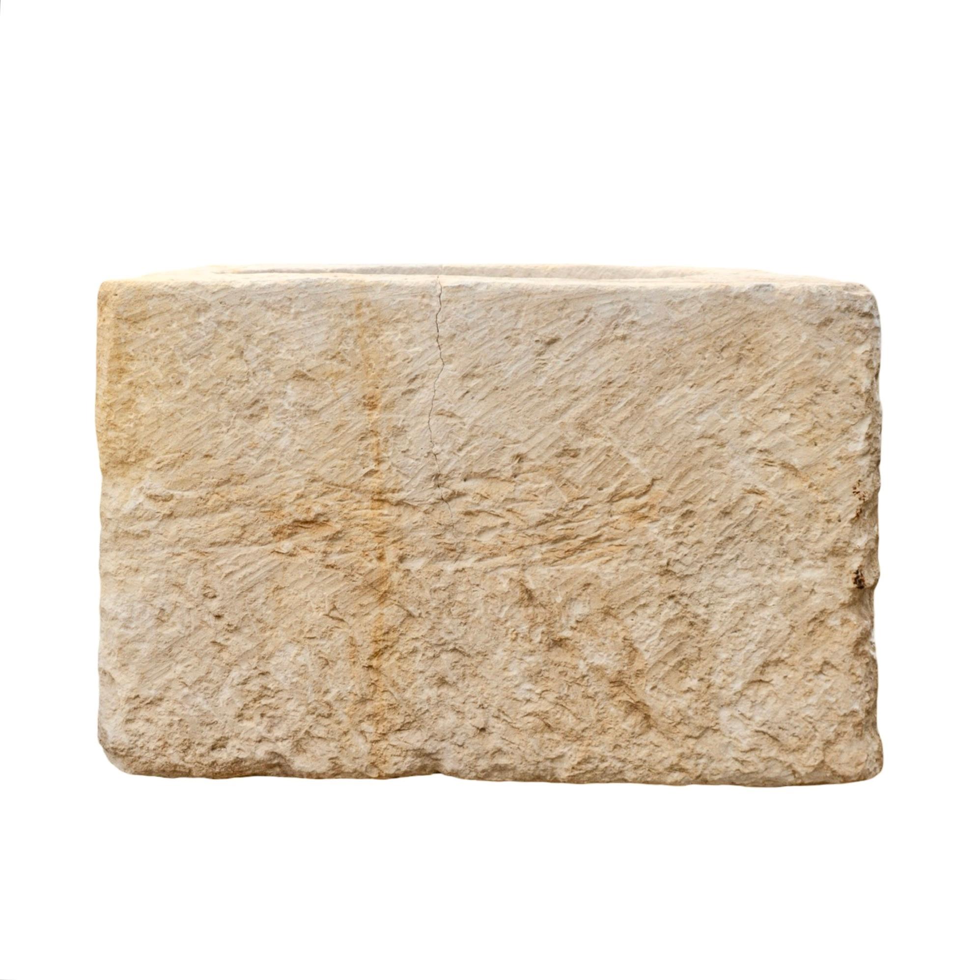 Un antico vaso in pietra calcarea recuperato, proveniente dalla Francia del XIX secolo. Progettato in stile angolare quadrato con un bacino circolare, conserva il foro di drenaggio originale, mostrando il suo passato funzionale. La superficie in