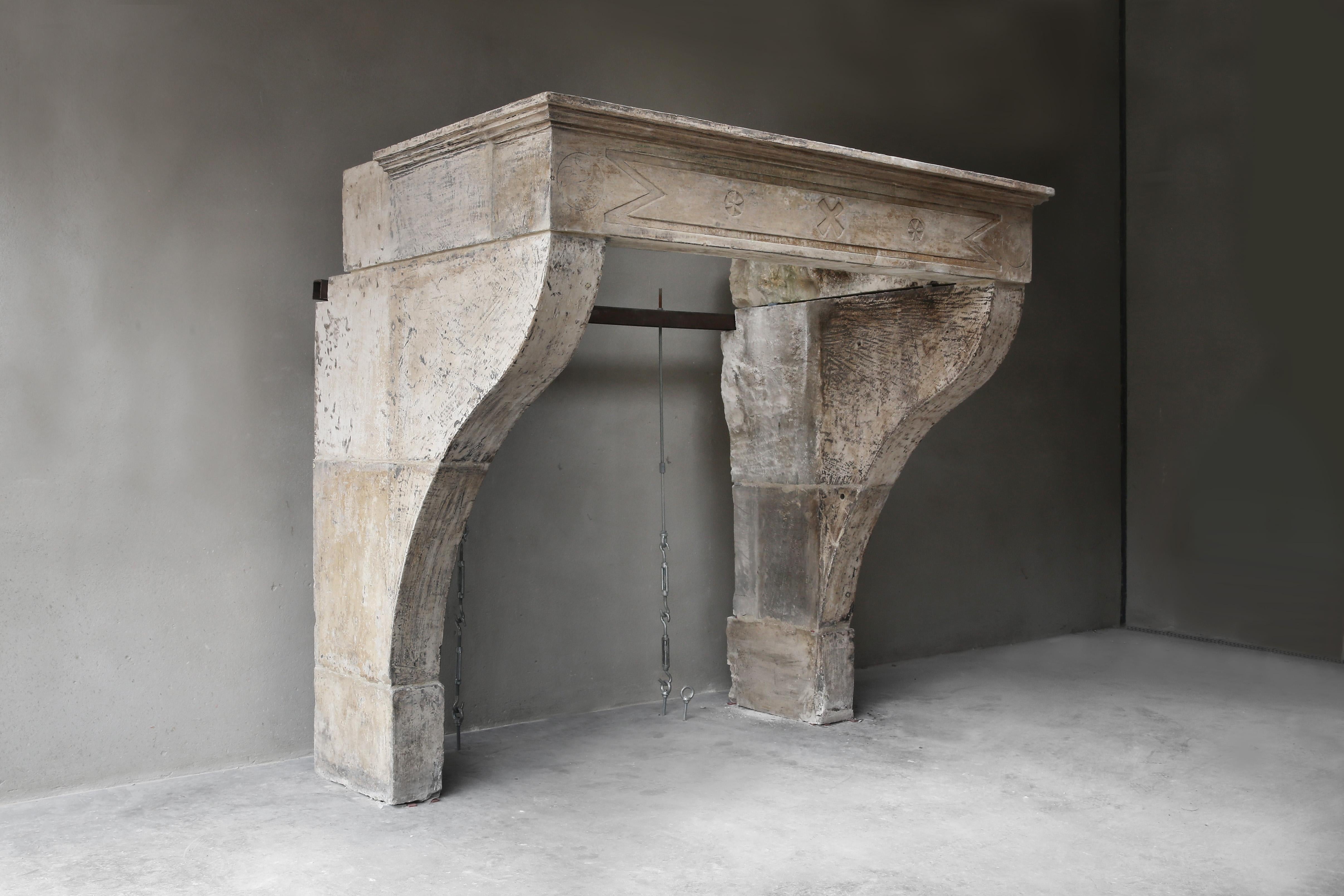 Beautiful robust and stately fireplace of French limestone from the 19th century. This antique fireplace is in Campagnarde style. The front part is decorated with various ornaments and the top has beautiful lines. The legs are slightly curved and