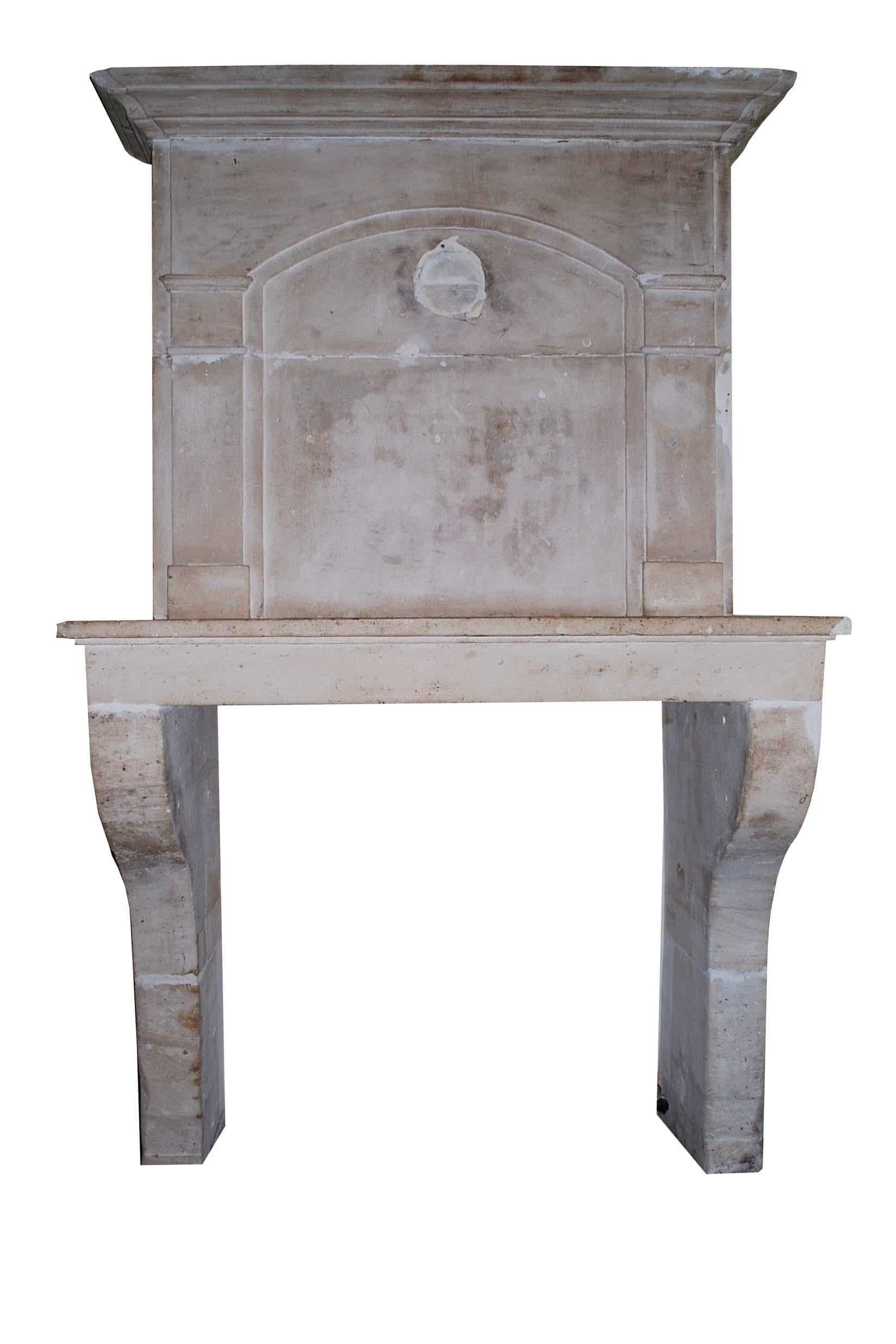 A very handsome and rare antique fireplace that was made in France, circa 1720.
It is completely made in hand carved limestone. The addition of the authentic overmantel makes this piece truly special. The overmantel is decorated with columns