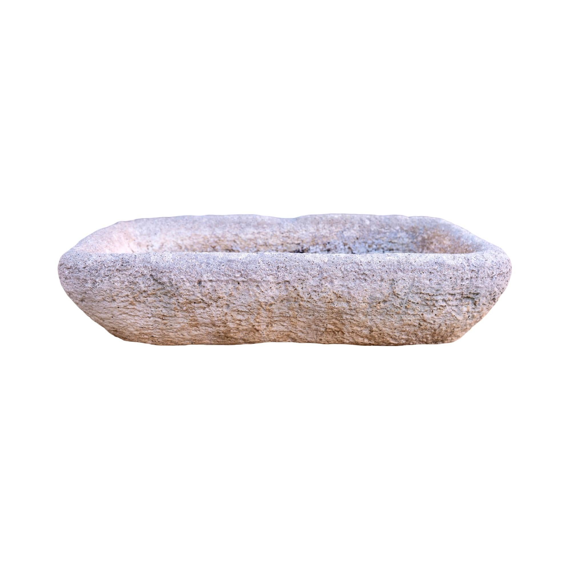 Un fregadero de piedra caliza antigua francesa recuperada del siglo XVIII, de tamaño pequeño y diseño de perfil bajo. Su pátina bellamente envejecida, su rica textura caliza y su carácter desgastado por el tiempo muestran su historia y su encanto.