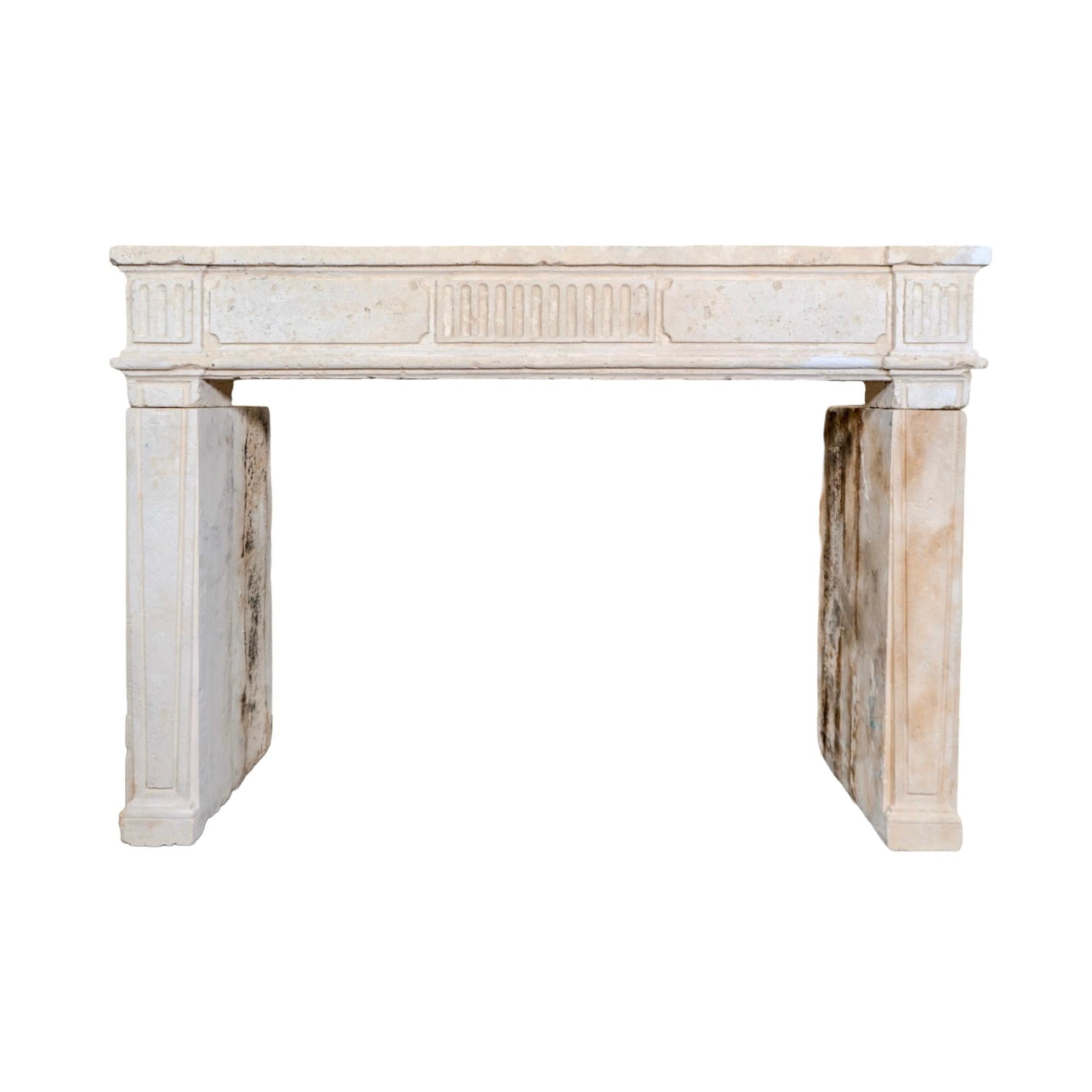 Tallada en piedra caliza en Francia durante el siglo XVIII, esta repisa presenta detalles estriados en el friso y jambas paneladas con refinadas tallas lineales. Su superficie recuperada muestra una suave pátina, la intemperie natural y el desgaste