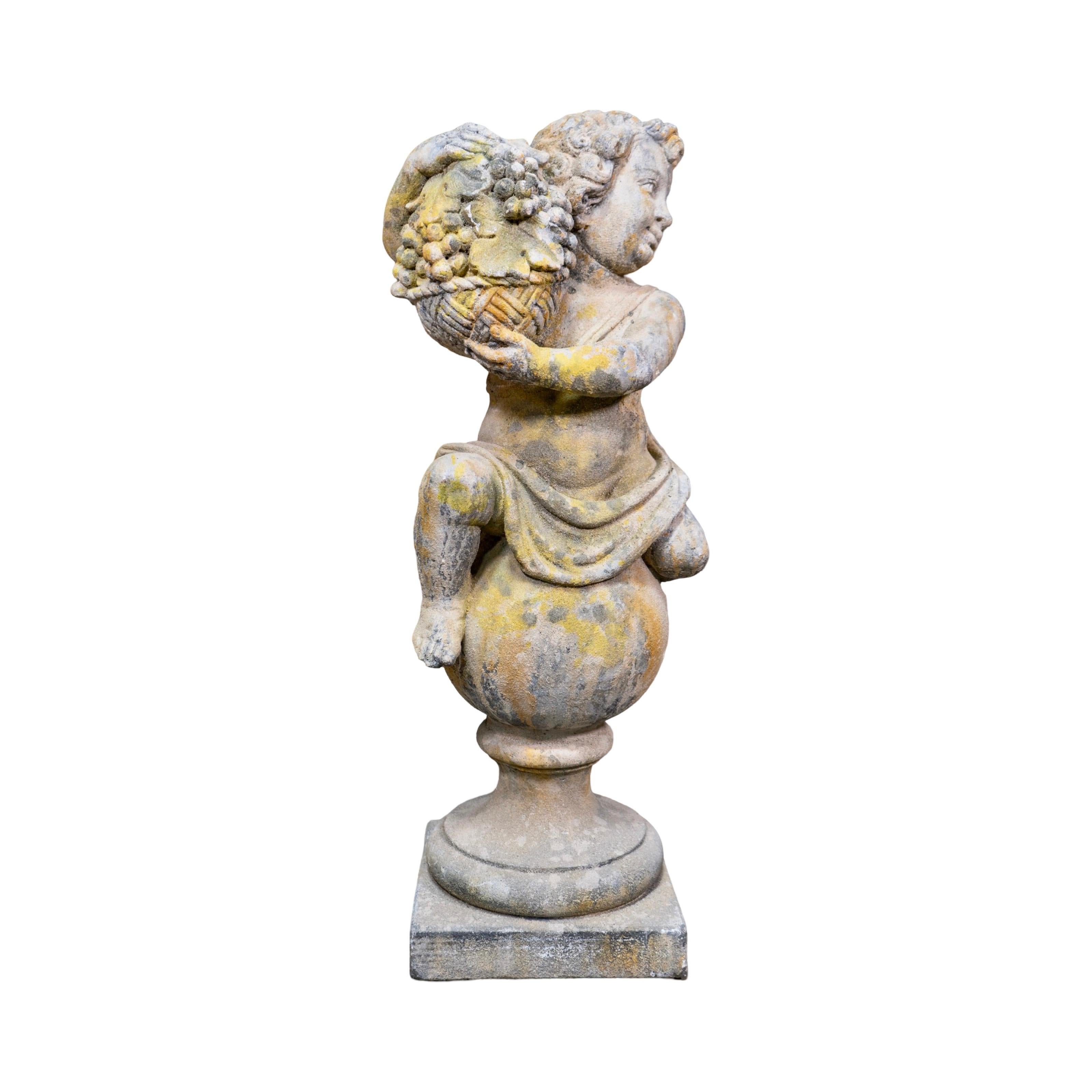Questa antica scultura di putti in pietra calcarea francese, recuperata in Europa, presenta un affascinante putti in cima a una palla rotonda che regge un cesto di frutta. Con un'usura caratteristica del XIX secolo, questa scultura aggiunge un tocco