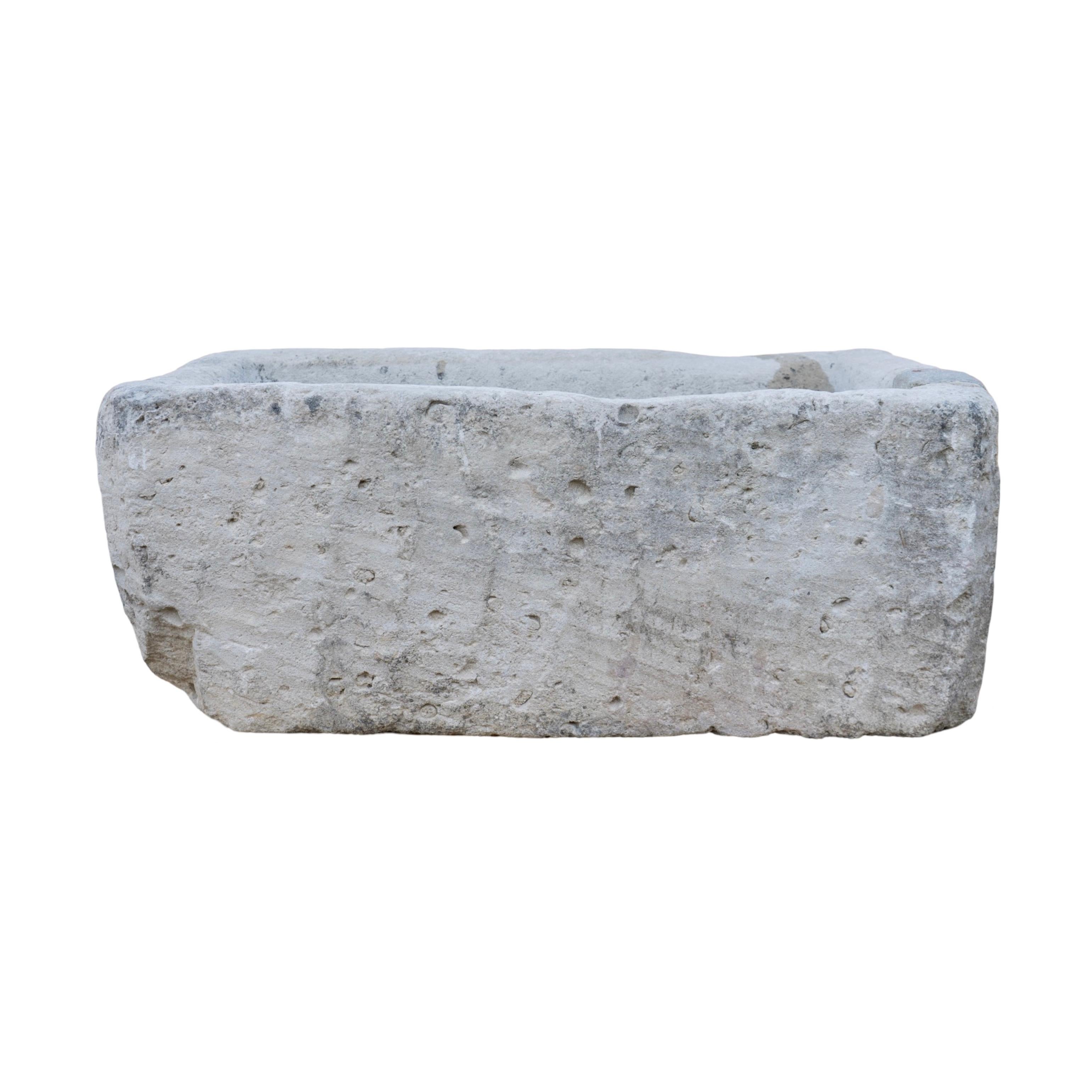 Une ancienne auge en pierre calcaire du XVIIIe siècle, récupérée en France, arbore une forme rectangulaire classique et dégage un caractère intemporel grâce à son usure naturelle et à son charme vieilli. Parfaite pour mettre en valeur des fleurs,
