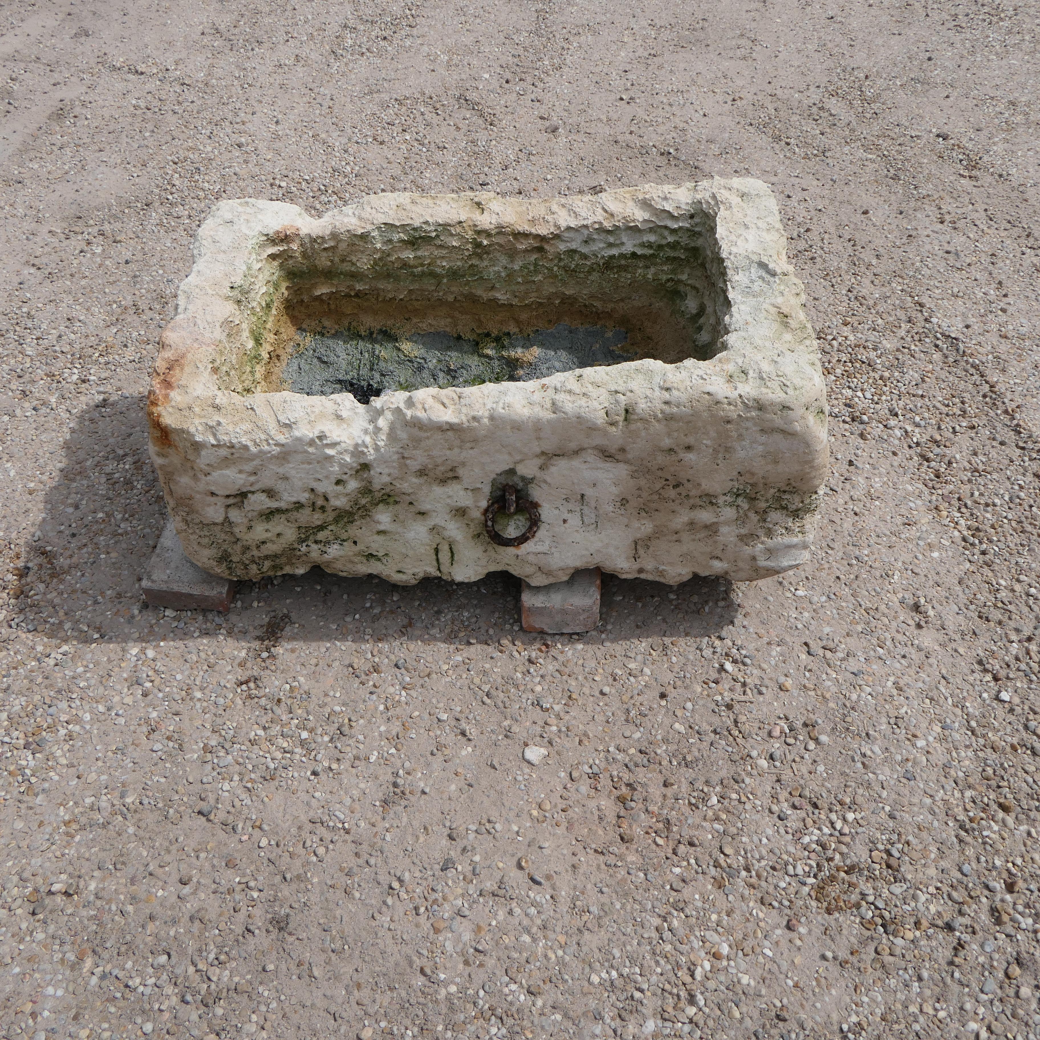 A beautifully weathered antique French limestone trough, hand-carved in the 18th century. Originally used on a rural farmstead, this solid stone basin features a naturally aged patina and charming irregularities that speak to its authenticity and