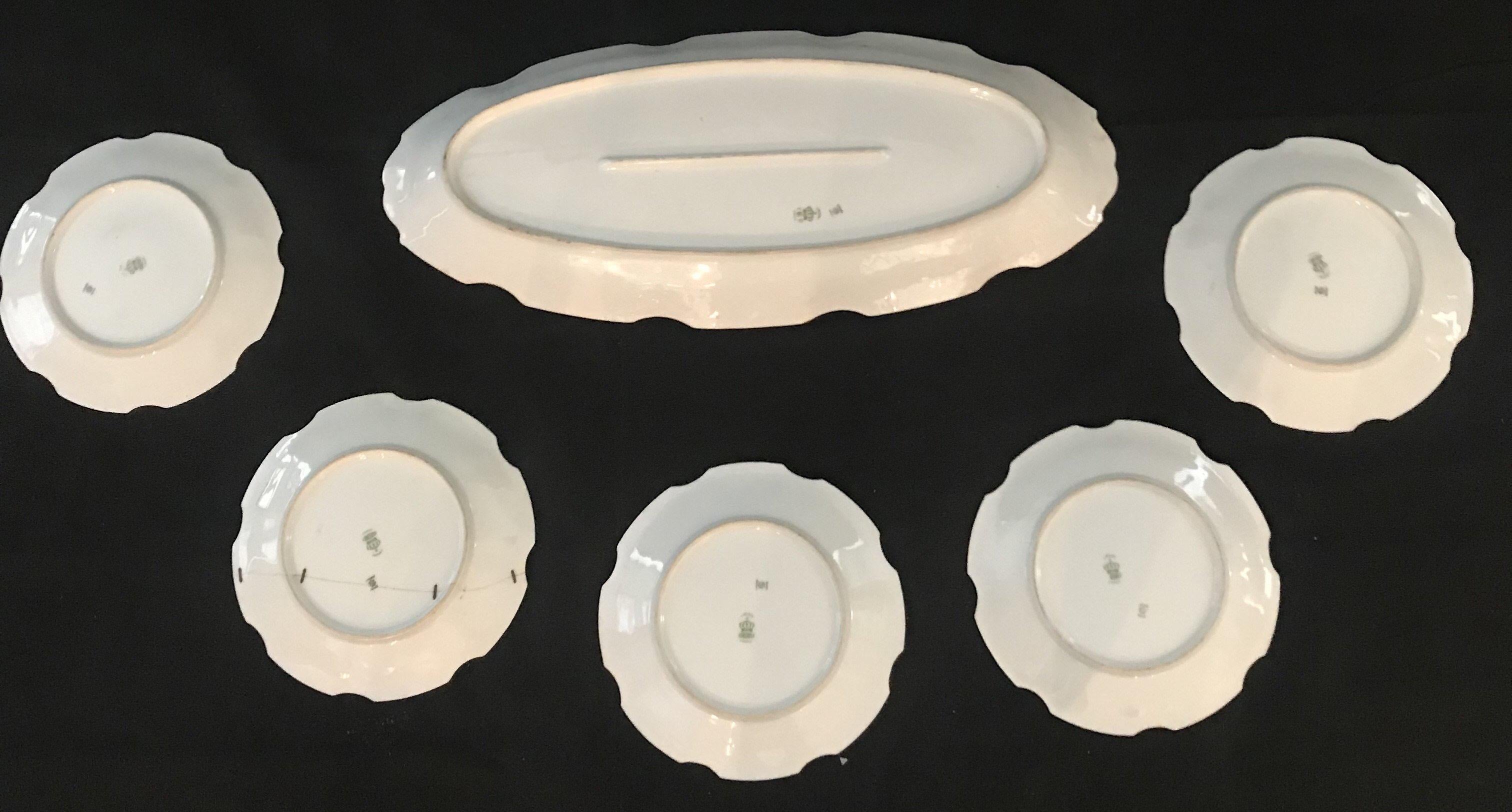 A vibrant set of five Limoges, France Bonet fish plates and one platter. Each plate and the platter are signed! A nicely shaped plate accented with 24-karat gold and completely hand painted and individually signed with flora and fish throughout; a