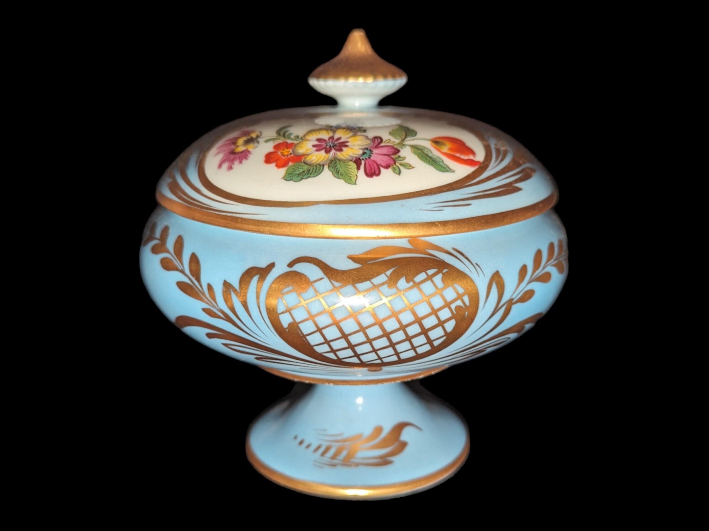 Questa antica ciotola francese con coperchio con piedini floreali di Limoges, di colore azzurro e dorati, è un esempio mozzafiato di fine artigianato della porcellana della rinomata regione di Limoges, in Francia. La base morbida e azzurra della