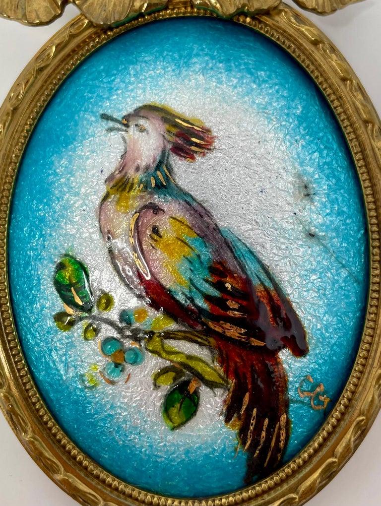 Antique French Limoges Enameled Porcelain Bird in an Ormolu Frame, Circa 1910-1920.
Pretty painted porcelain bird with enameling in striking blue and white colors with umber, lilac, green, yellow & gold accents.  