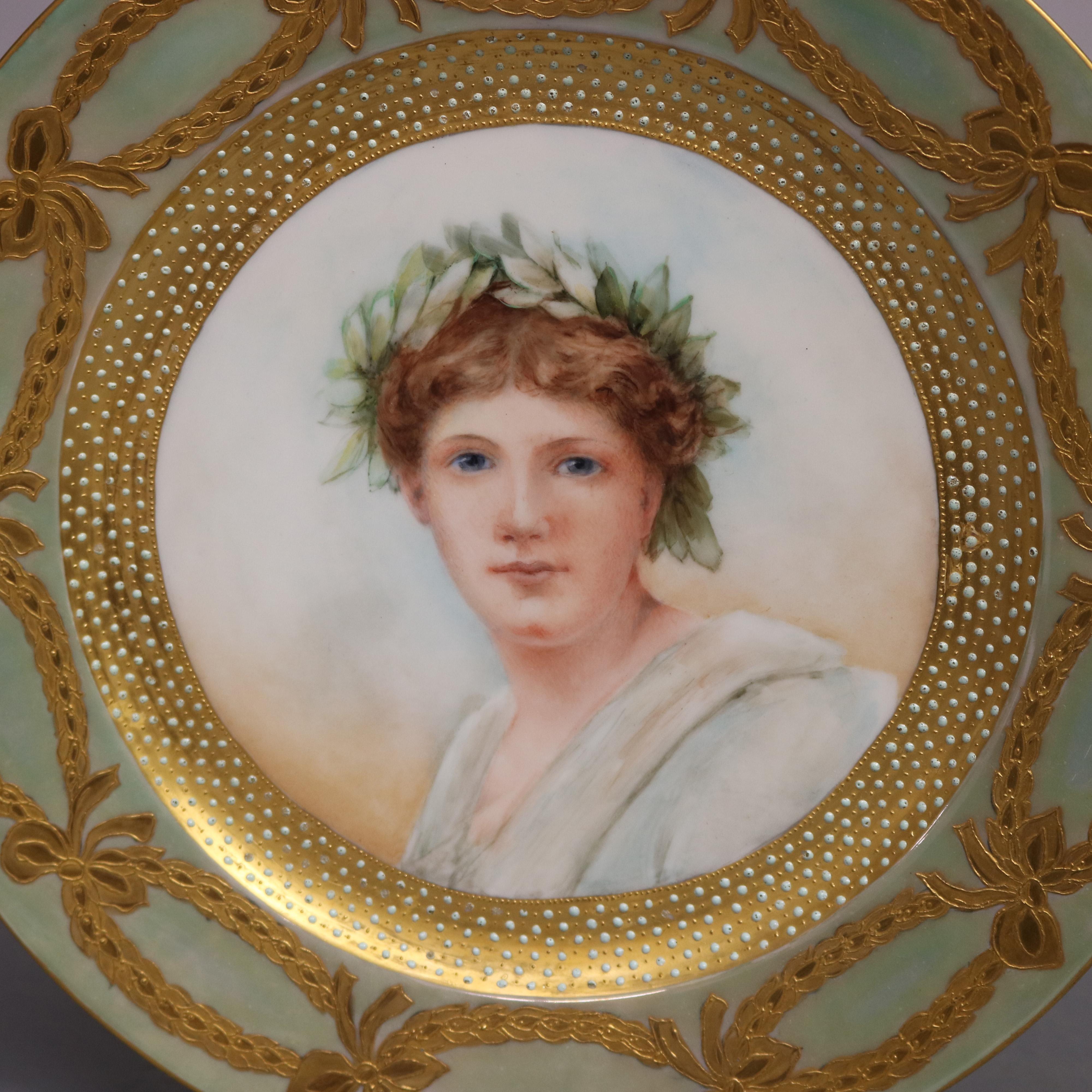 Antique French Limoges portrait plate features well with portrait of young woman in oak leaf crown, rim decorated with gilt ribbon and bow motif, en verso artist signed Scluette, 19th century

Measures: 1