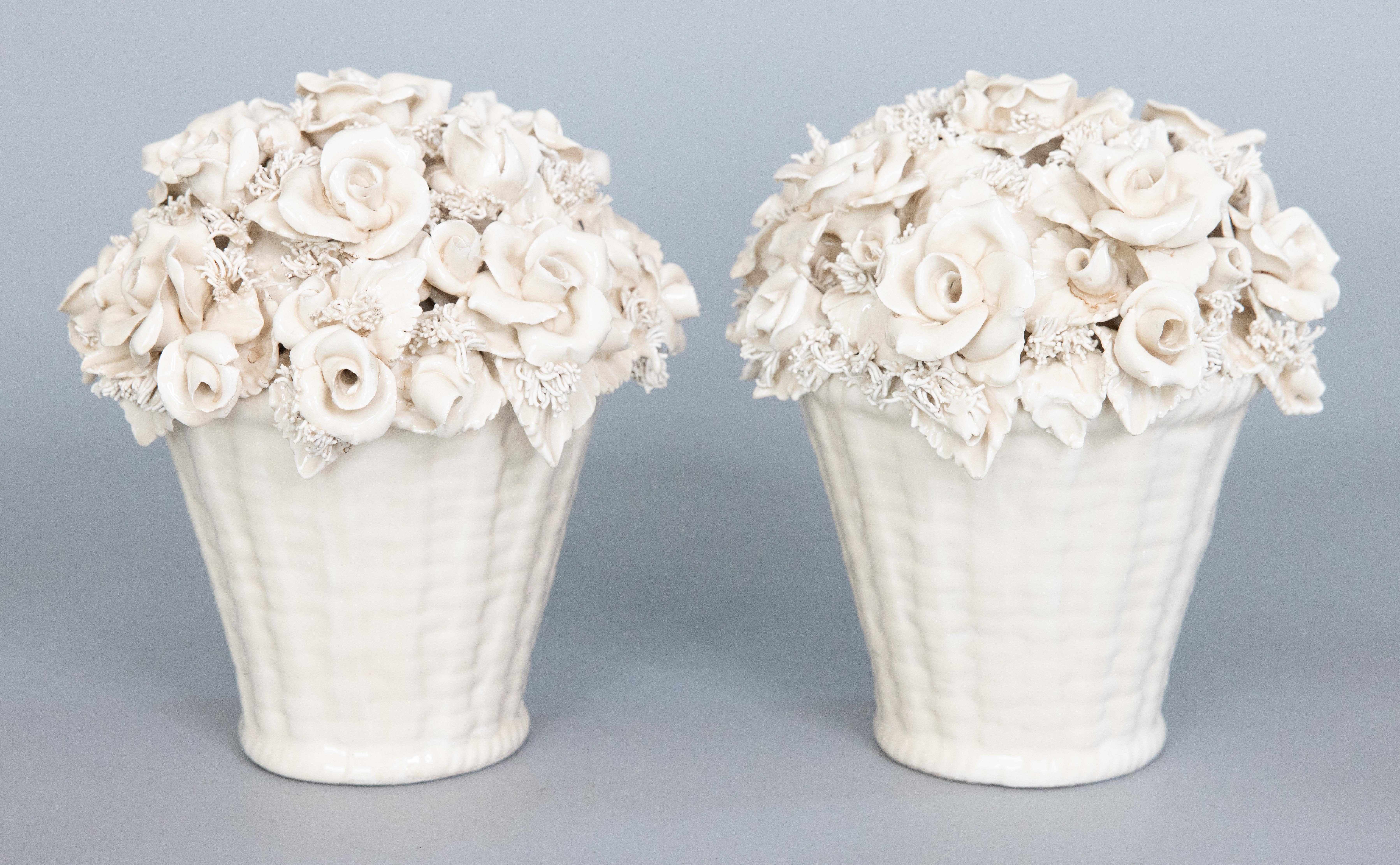A gorgeous pair of antique early 20th-Century white porcelain creamware rose baskets flower arrangements from Limoges, France. Maker's mark on reverse. These stunning arrangements feature a hand molded assortment of roses and leaves with exquisite