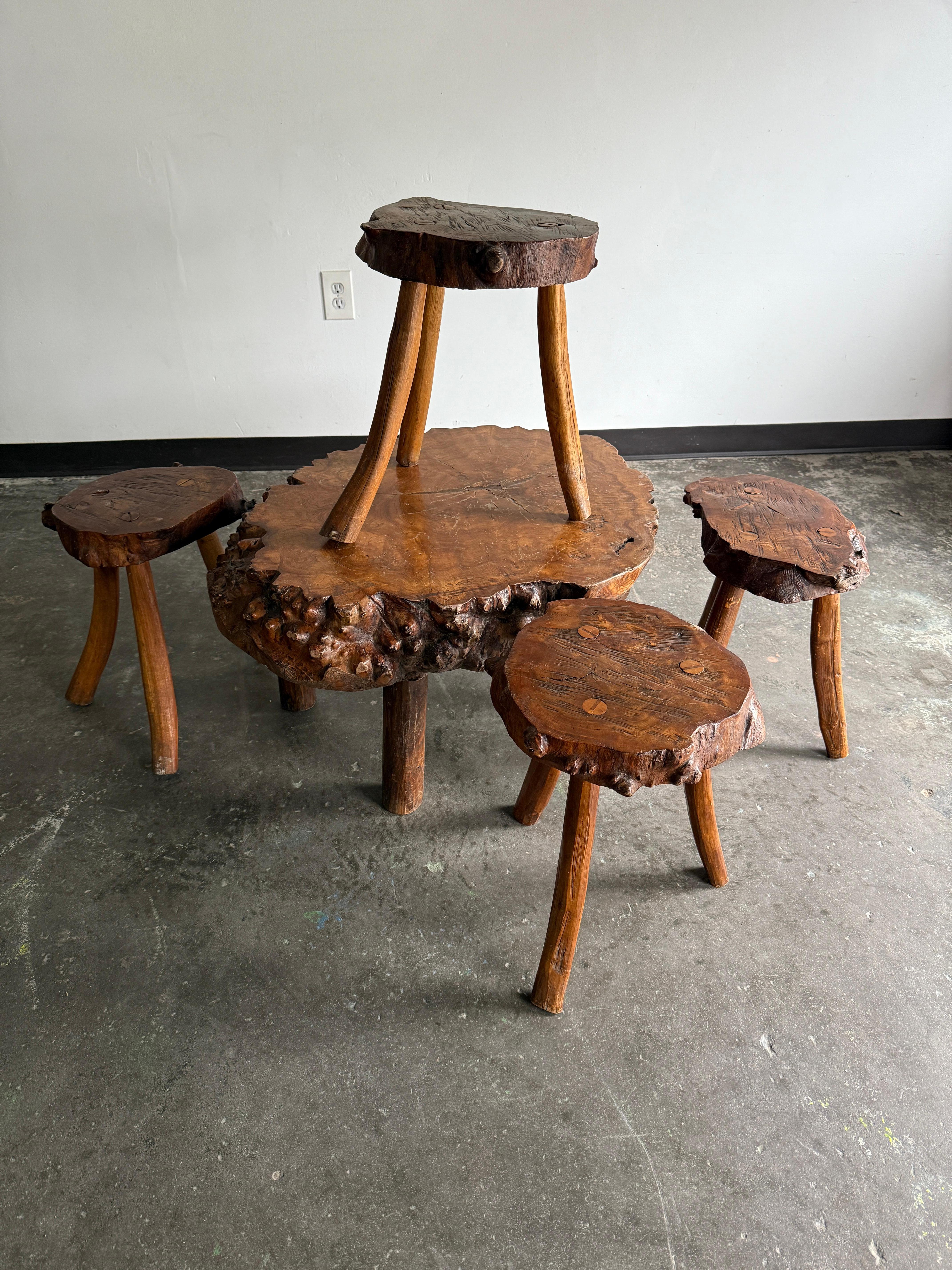 Unique burled wood slab live edge coffee/center table with 4x stools/drink tables (five pieces total). In excellent vintage condition. The center/coffee table is incredibly heavy and would require one very strong/two average folks to lift. Would