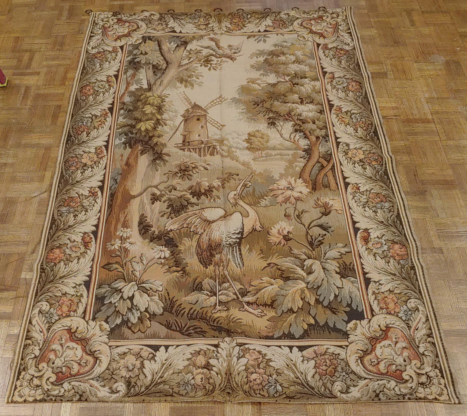 This is an exquisite French loomed tapestry. These tapestries were machine loomed in the early 20th century to compete with the hand-woven Aubusson and Flemish tapestries. This one is decorated with a beautiful crane in the foreground and a wind