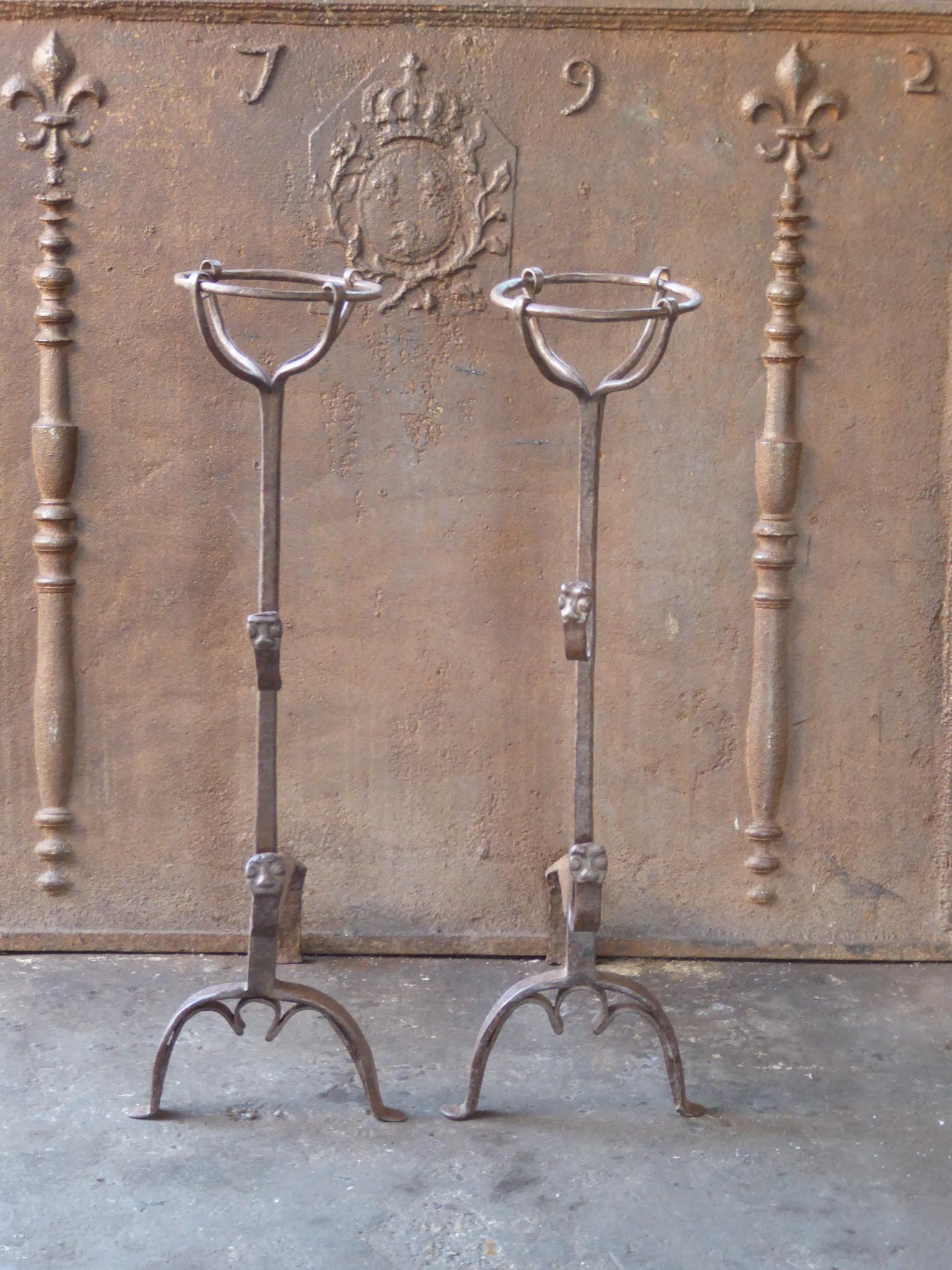 Beautifully forged 17th century French andirons made of wrought iron. The style of the andirons is Louis III. The andirons have decorated spit hooks to grill food. They are in a good condition.