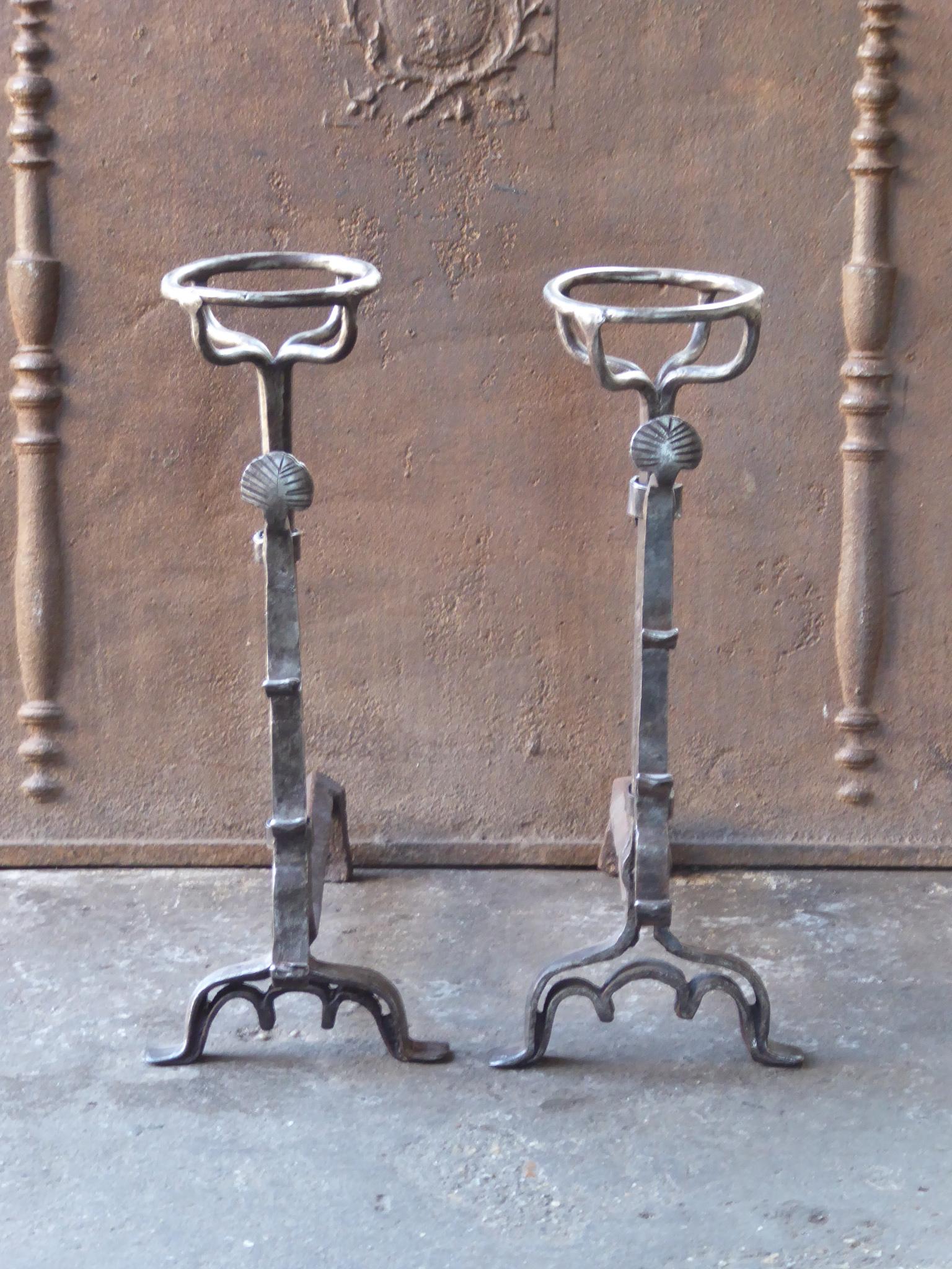 Beautifully forged 17th century French andirons made of wrought iron. The style of the andirons is Louis III. The andirons have decorated spit hooks to grill food. They are in a good condition.